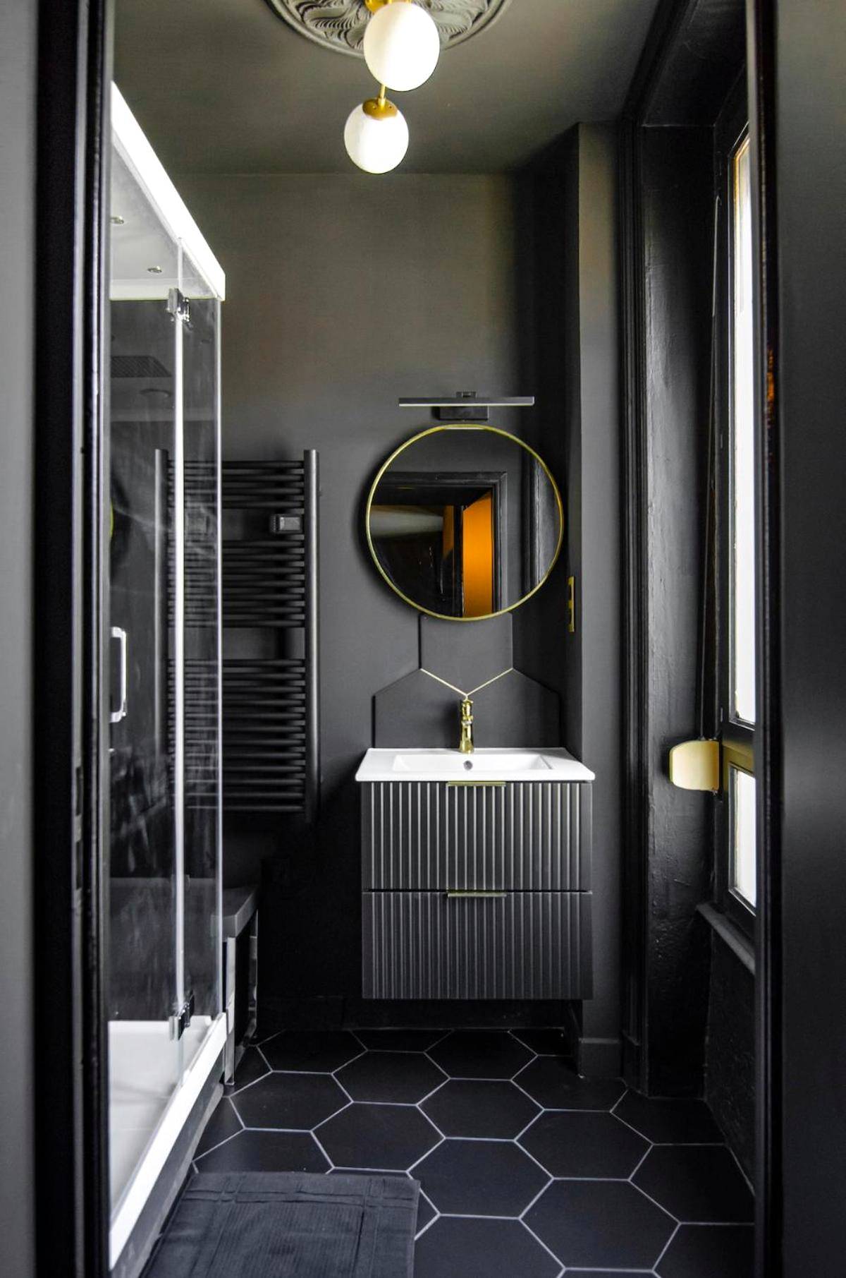 Salle d'eau moderne avec vasque et miroir rond - Suite Balneo Hammam Noire et Or