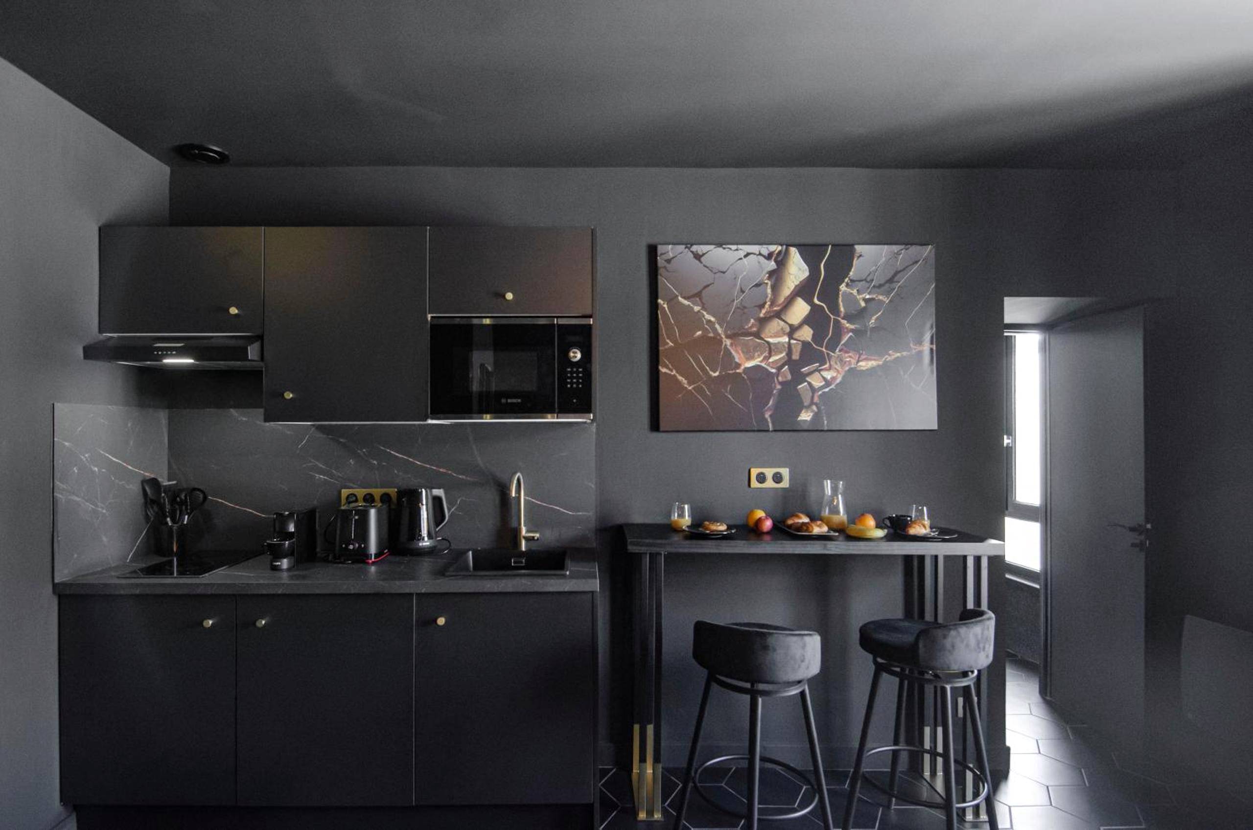 Cuisine équipée noire avec coin repas - Suite Balneo Hammam Noire et Or