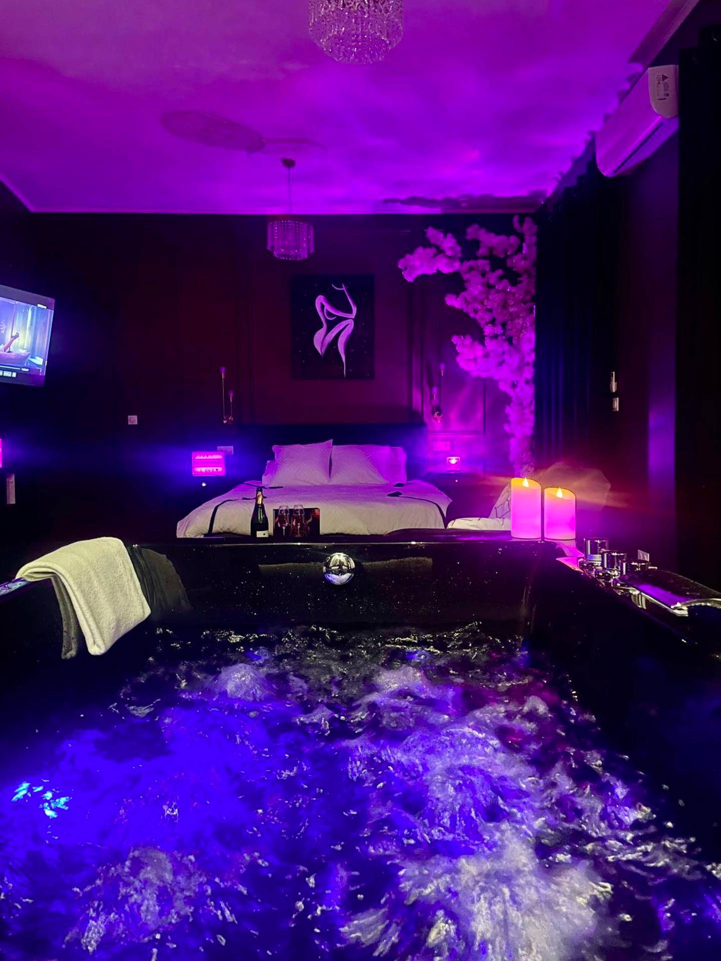 Jacuzzi privatif avec éclairage bleu et violet - Love Room Roanne - Suite romantique avec Balneo et jeux coquins