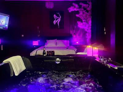 Jacuzzi privatif avec éclairage bleu et violet - Love Room Roanne - Suite romantique avec Balneo et jeux coquins