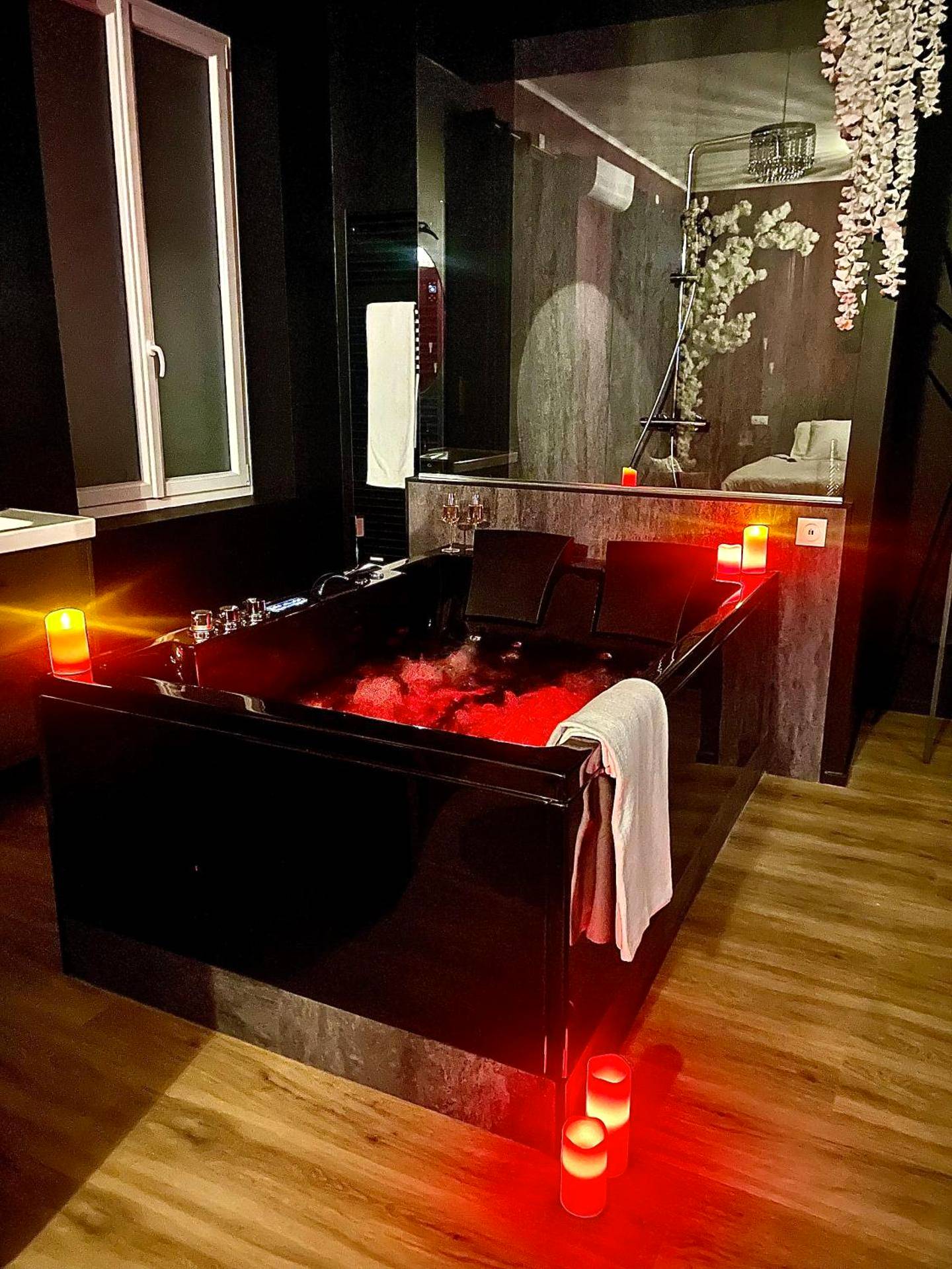 Baignoire balnéo noire éclairée en rouge - Suite romantique avec Balneo et jeux coquins