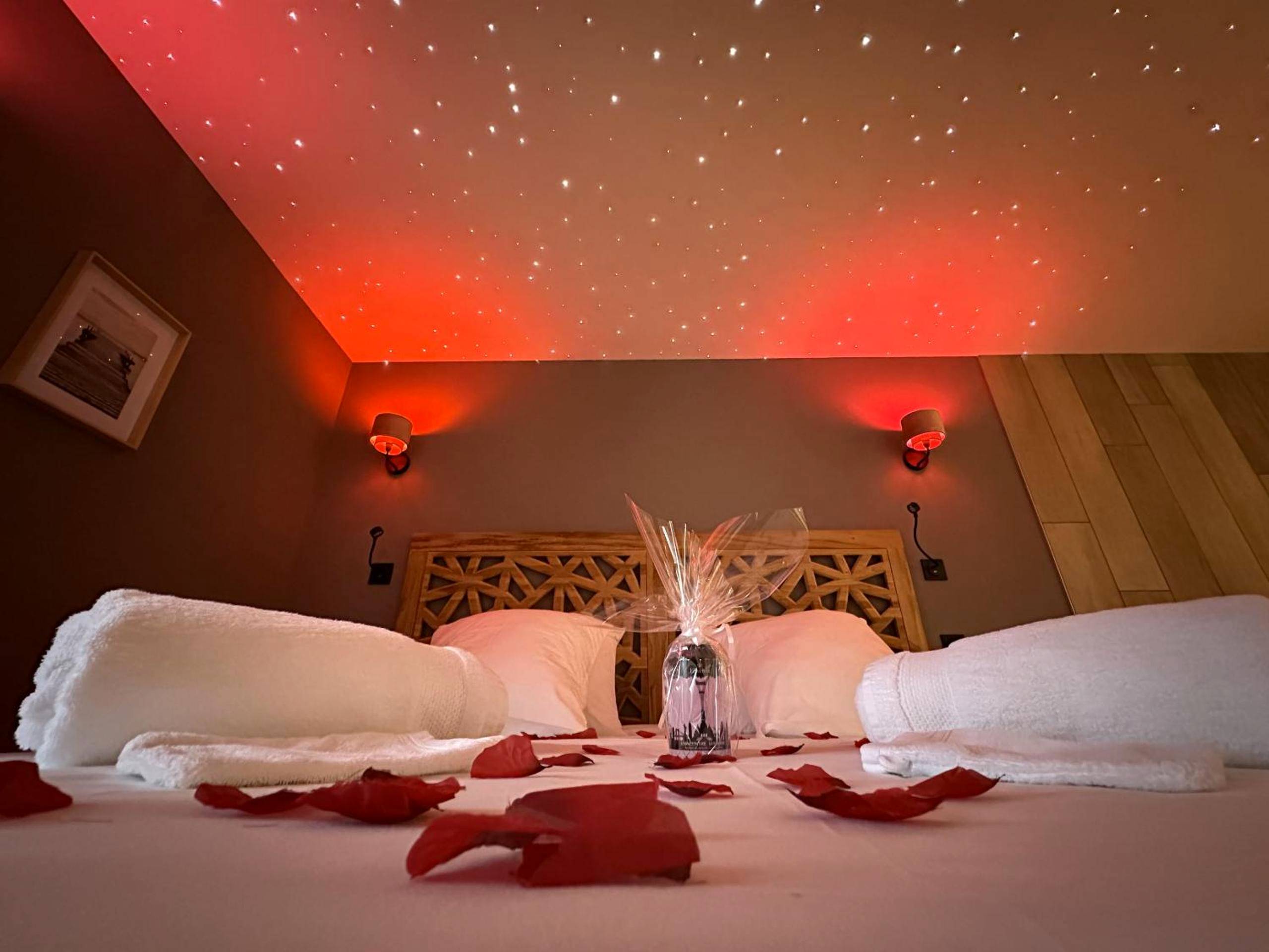 Lit avec pétales de rose et ciel étoilé - Love Room Saint - Laurent - d'Andenay - La Suite Bien Être & Luxe au Domaine...