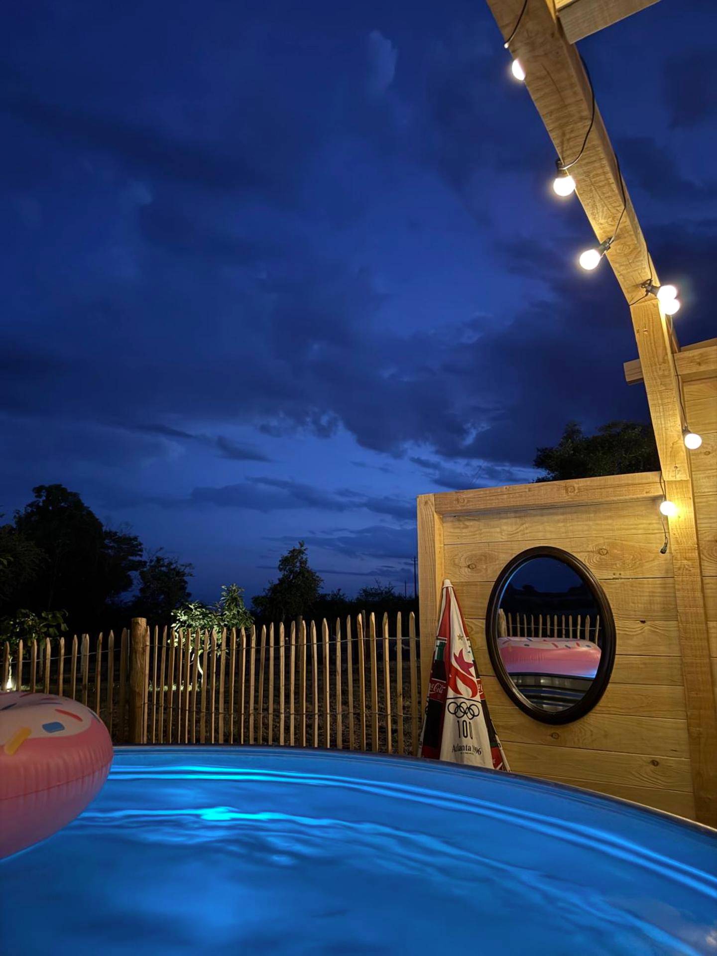 Piscine extérieure éclairée à la tombée du jour - La Suite Bien Être & Luxe au Domaine du Moulin