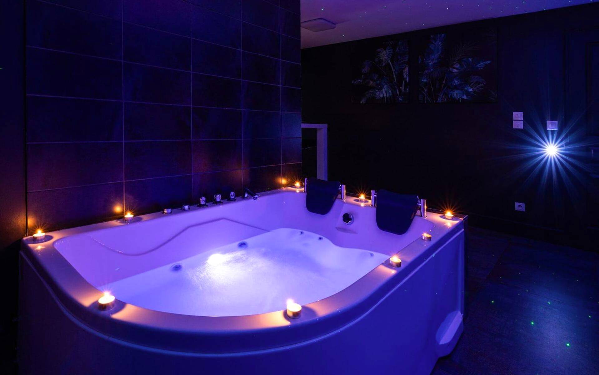Baignoire balnéo éclairée entourée de bougies - Suite Boréale 50m2 spa privatif.