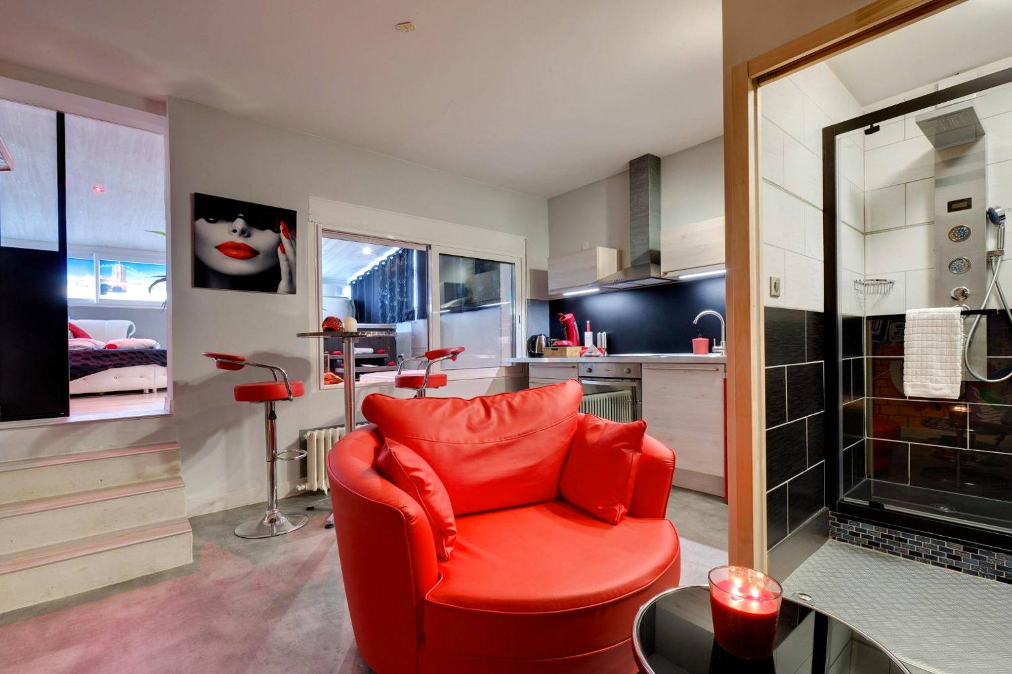 Fauteuil rouge, coin cuisine et douche à jets - SUITE BROOKLYN JACUZZI