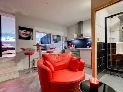 Fauteuil rouge, coin cuisine et douche à jets - SUITE BROOKLYN JACUZZI
