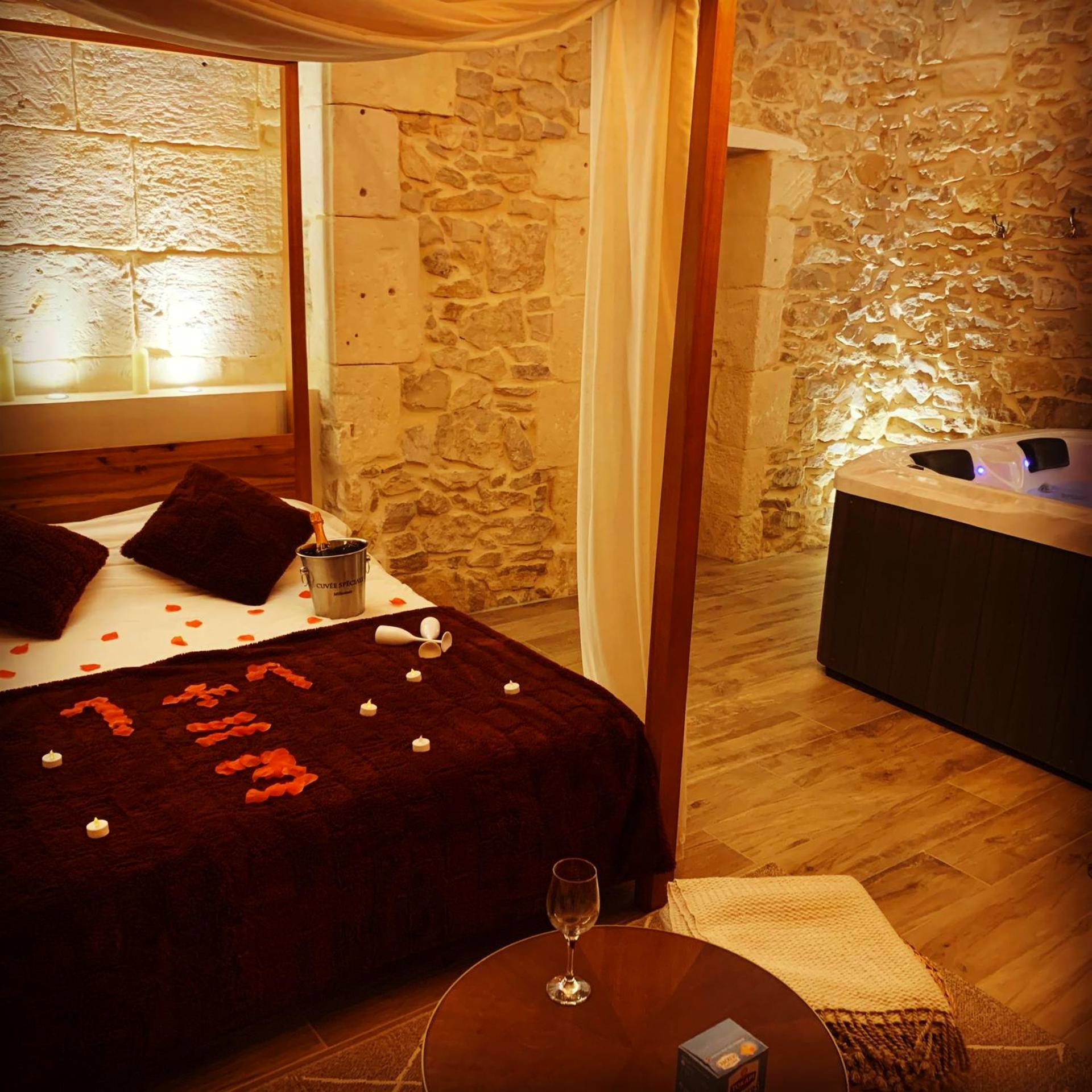 Lit avec pétales de rose et seau à champagne - Suite de caractère avec Jacuzzi