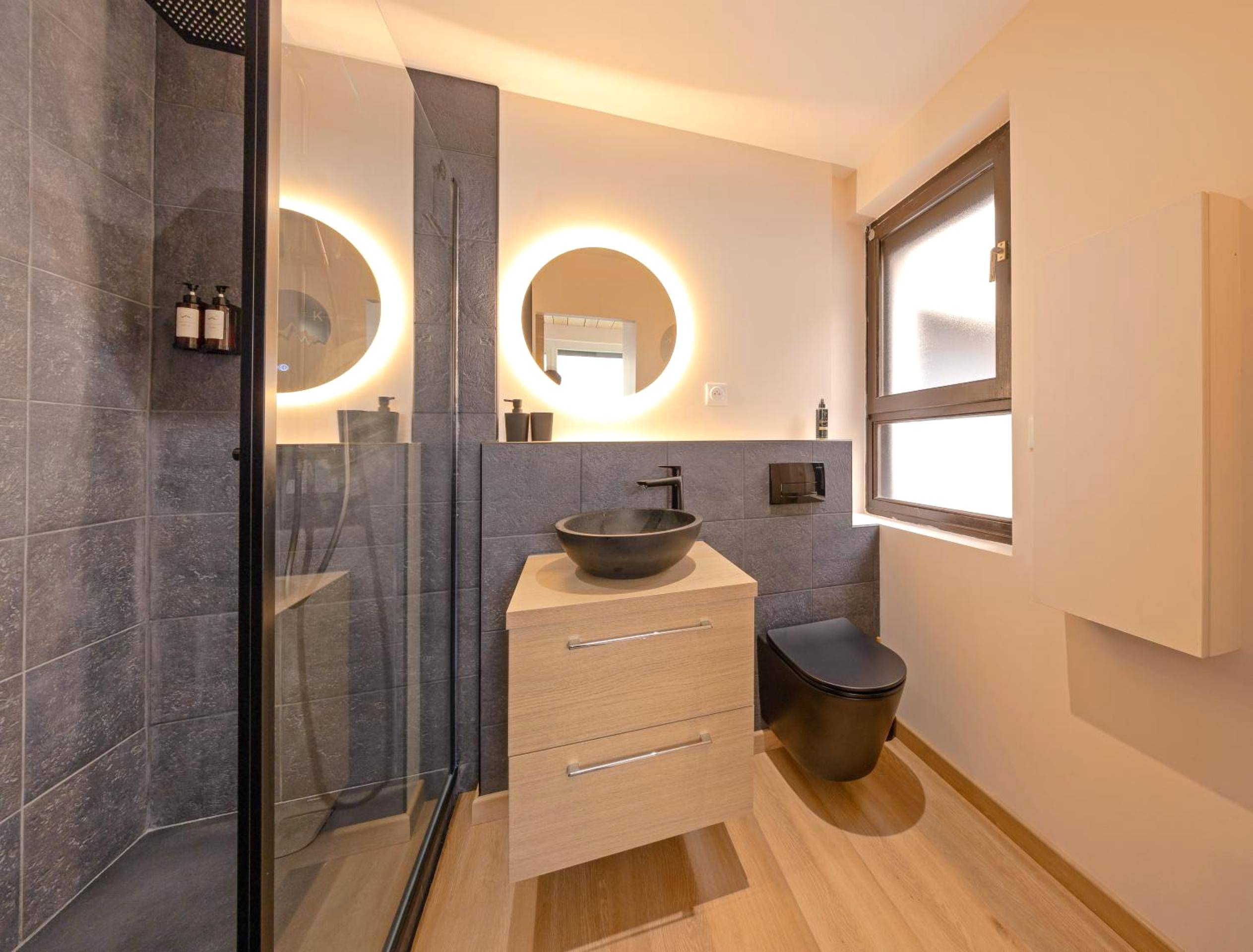 Salle de bain moderne avec miroir LED circulaire - Nid chaleureux Saint - Suite Chalet K - Hyper Centre - Gare