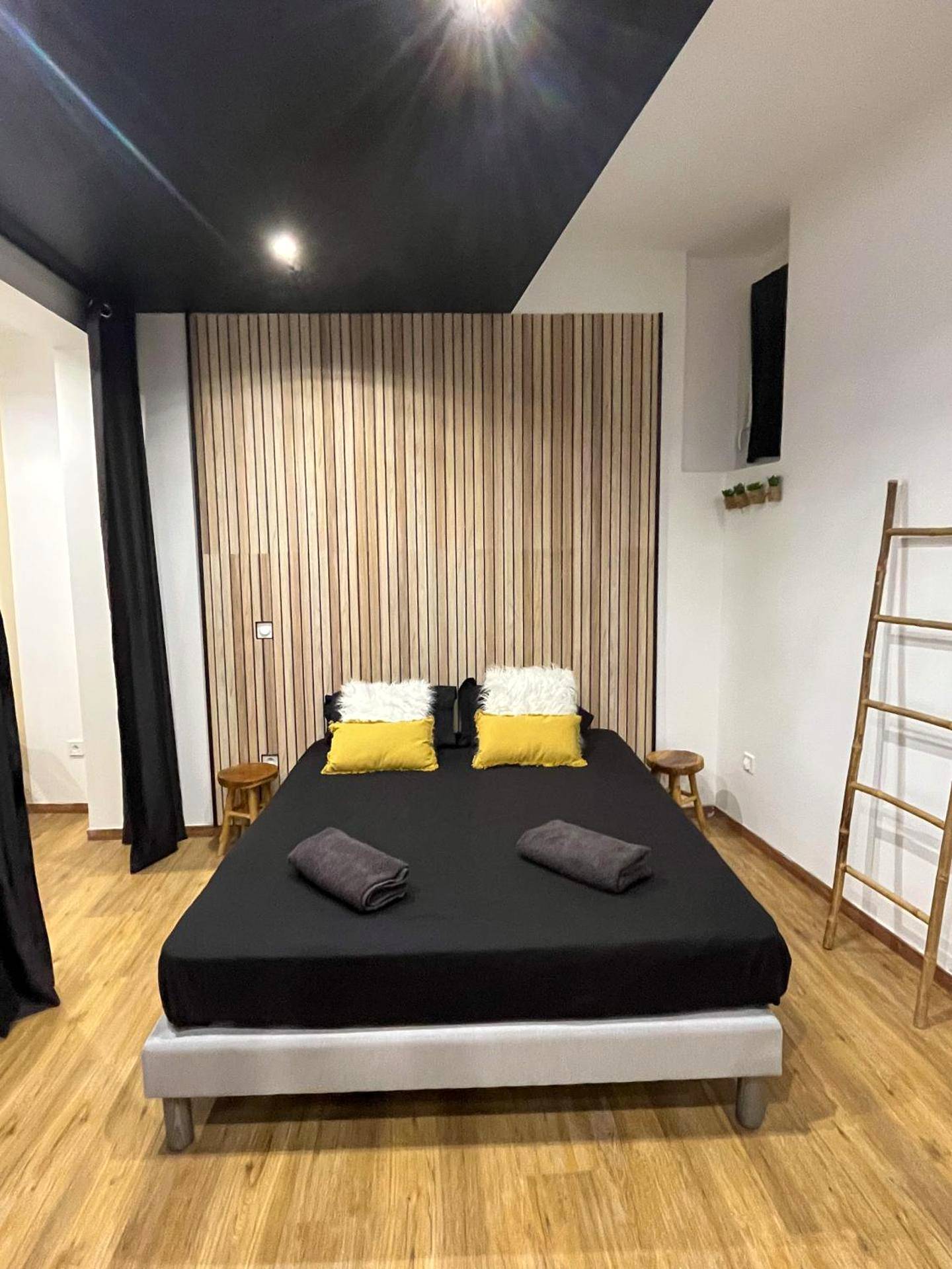 Lit double avec coussins jaunes et blancs - Suite cocooning & spa
