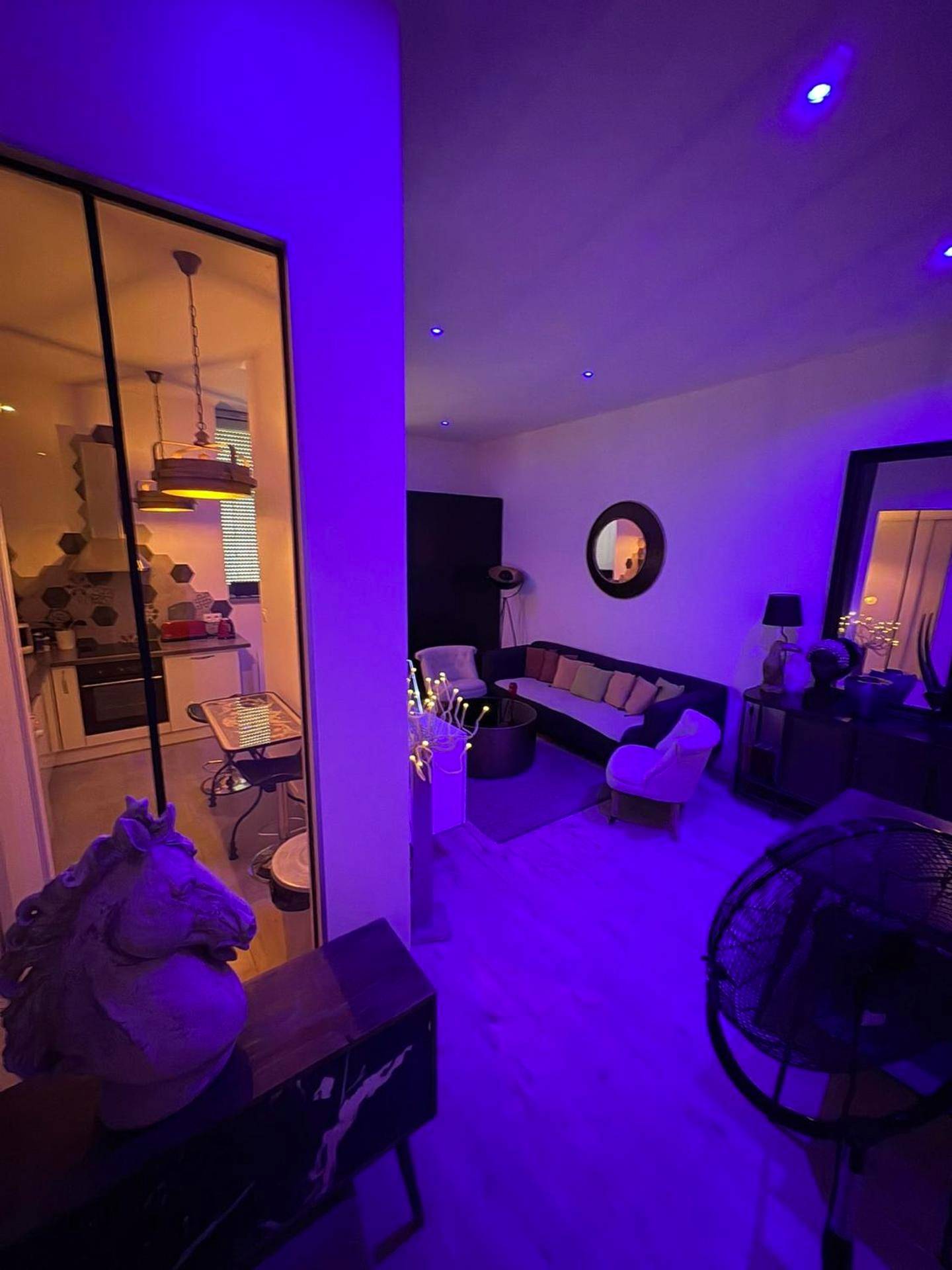 Espace de vie sous lumière d'ambiance violette - Suite Darcy & Spa