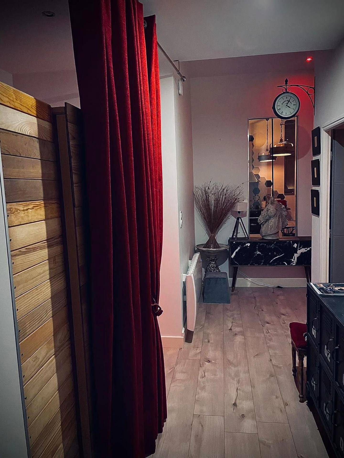 Entrée avec rideau rouge et horloge murale - Suite Darcy & Spa