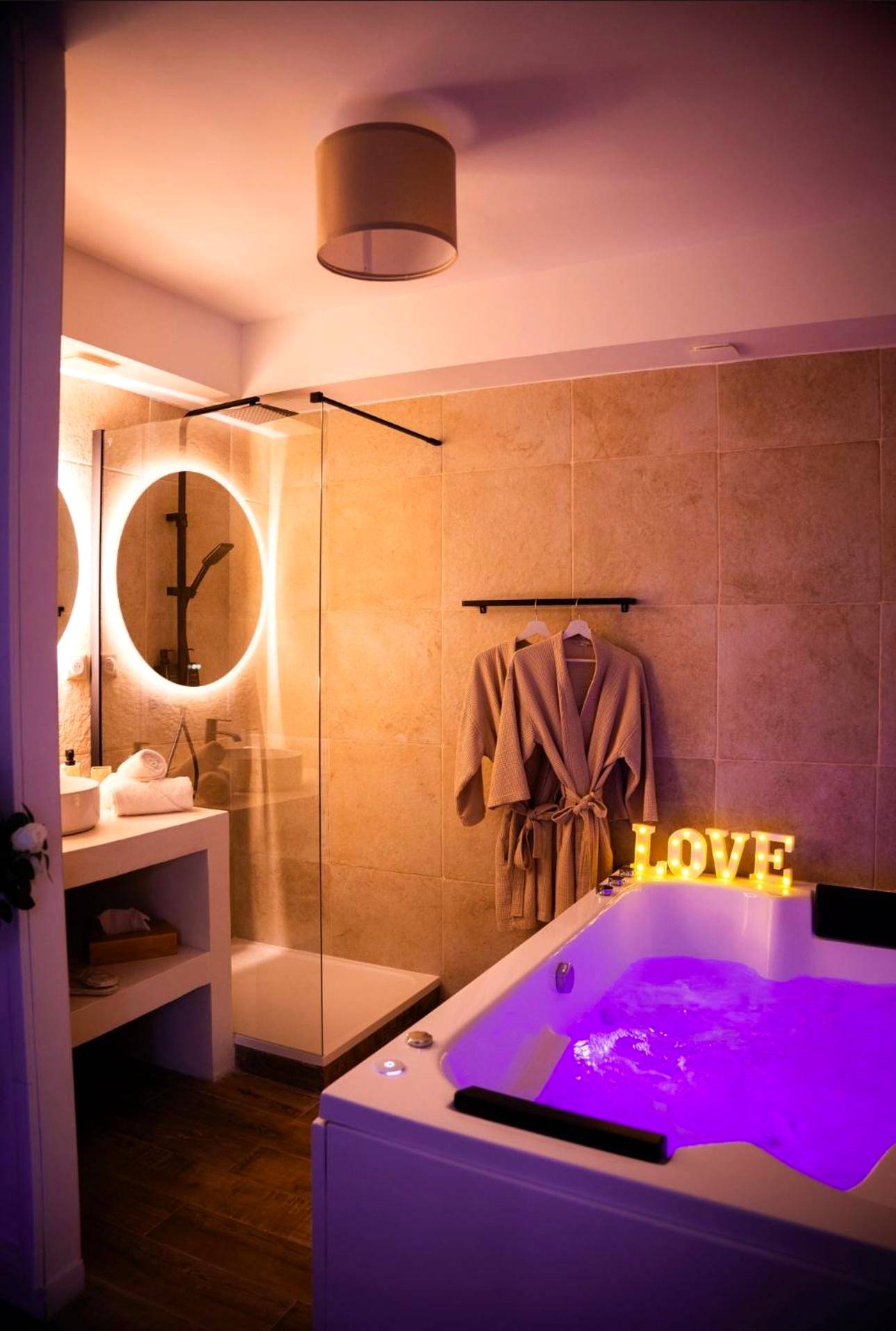 Jacuzzi privatif avec éclairage violet et néon - Love Room Neuilly - Plaisance - La Suite Delma