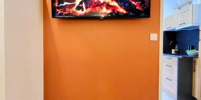 Écran plat diffusant un feu de cheminée - - LA SUITE DELOS - JACUZZI 2 PLACES - CENTRE VILLE A PIED - LIT QUEEN SIZE -...