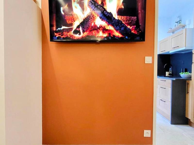 Écran plat diffusant un feu de cheminée - - LA SUITE DELOS - JACUZZI 2 PLACES - CENTRE VILLE A PIED - LIT QUEEN SIZE -...