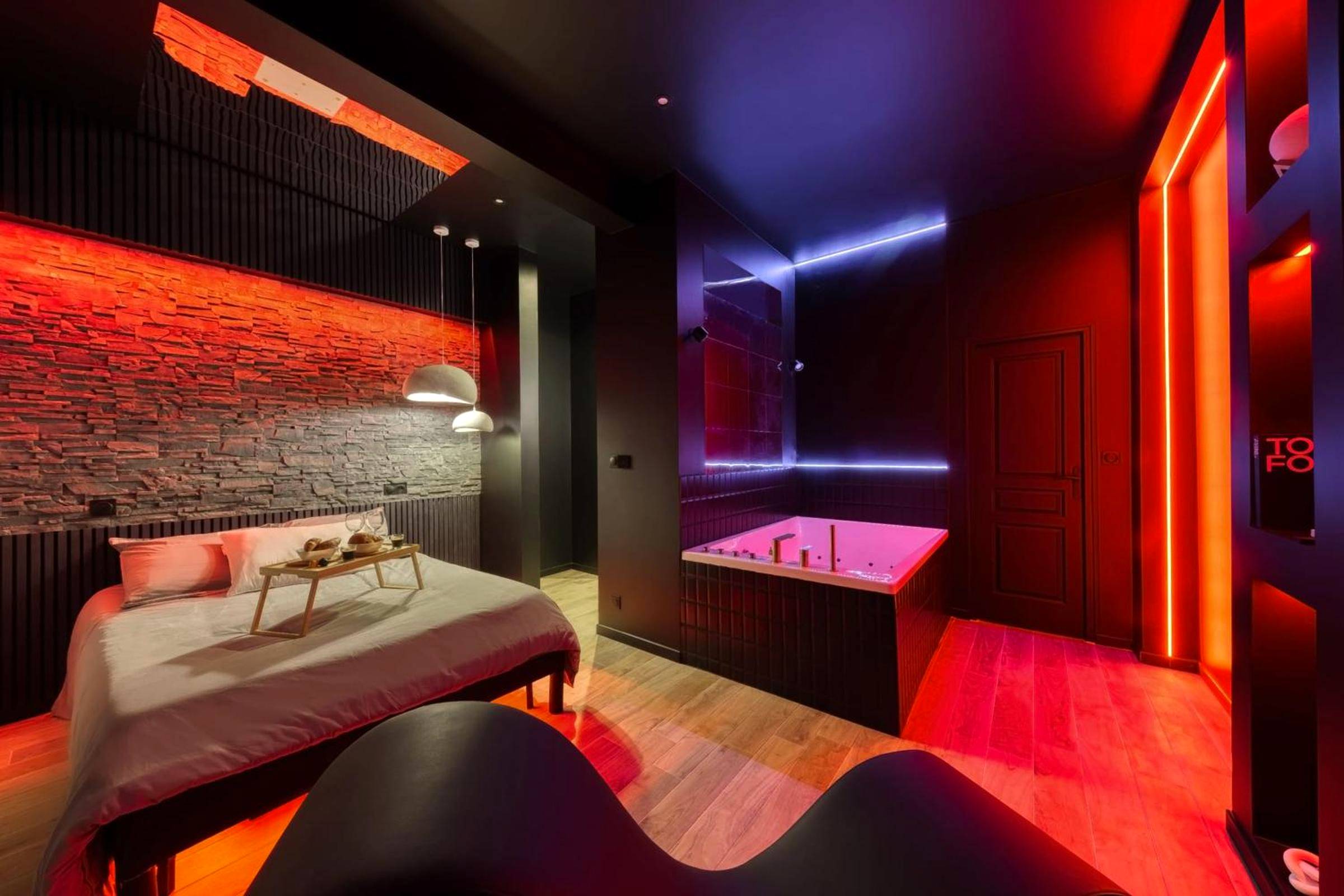 Lit double et jacuzzi avec néons rouges - Love Room Melun - Suite Deluxe - Jacuzzi
