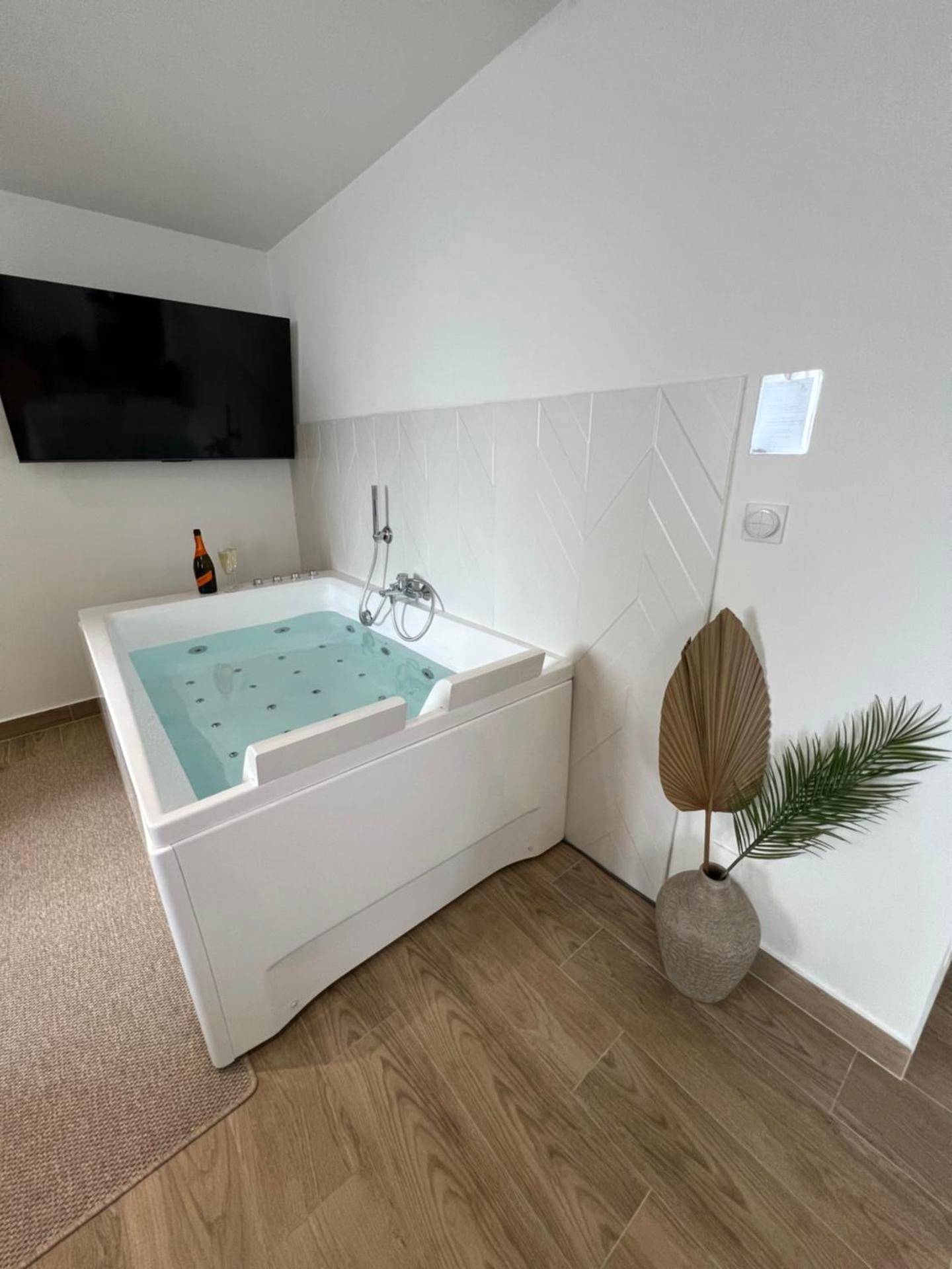 Jacuzzi rectangulaire blanc et écran plat - Suite Détente - Spa & Sauna