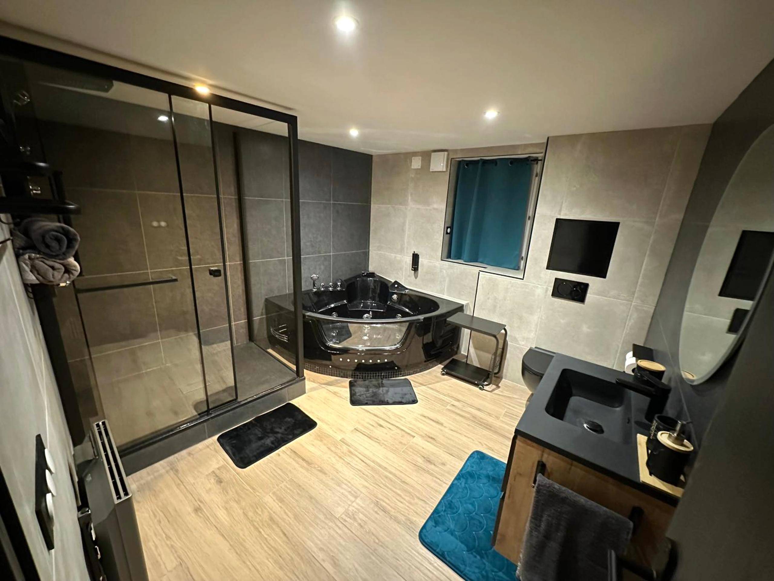 Salle de bain avec jacuzzi noir et douche - Love Room Vizille - Suite L'échappée Belle
