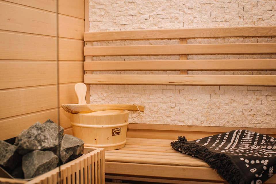 Détail du sauna avec seau et louche en bois - La Suite de l'Elixir