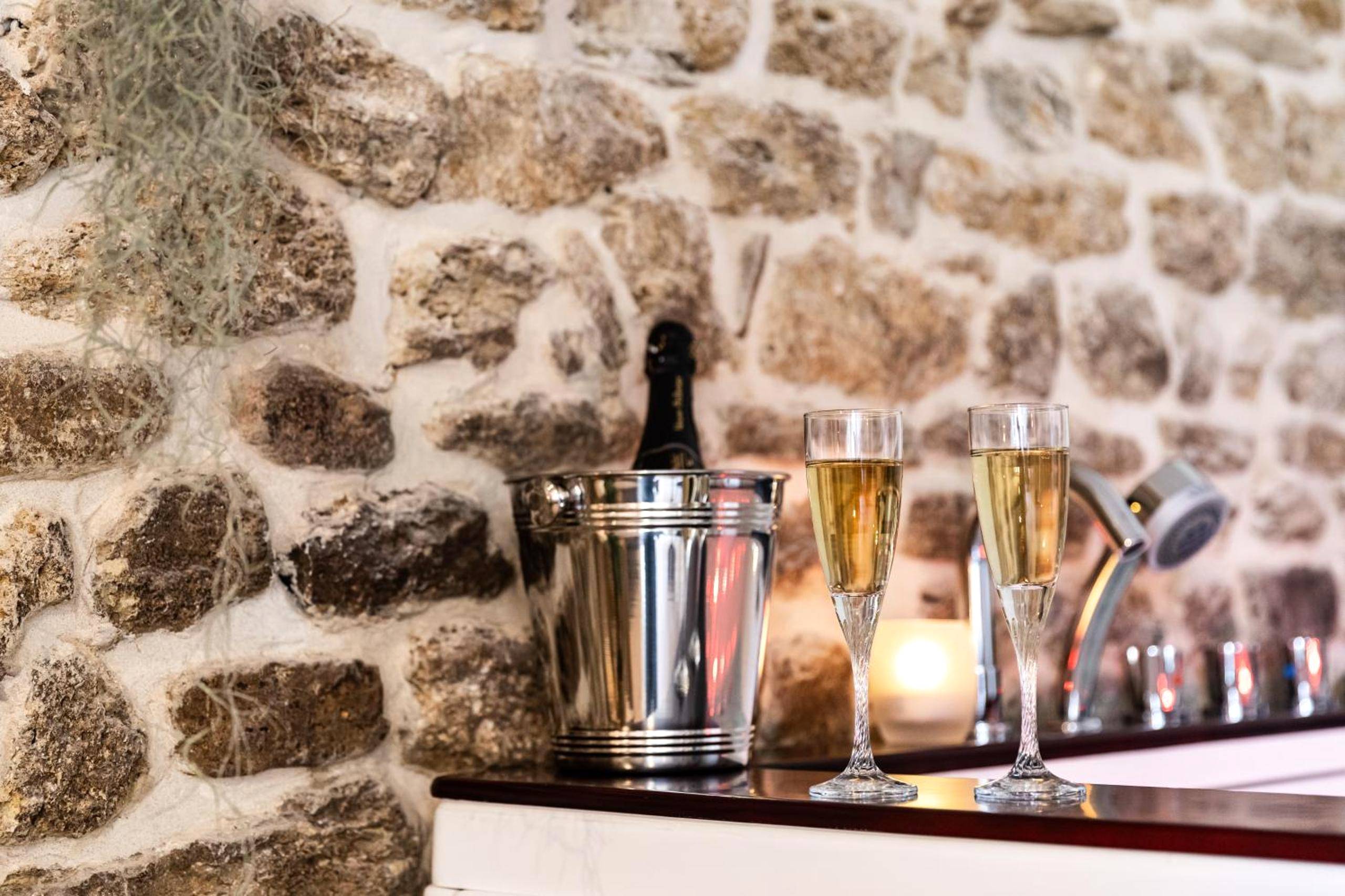 Flûtes et seau à champagne près du jacuzzi - La Suite de l'Etoile