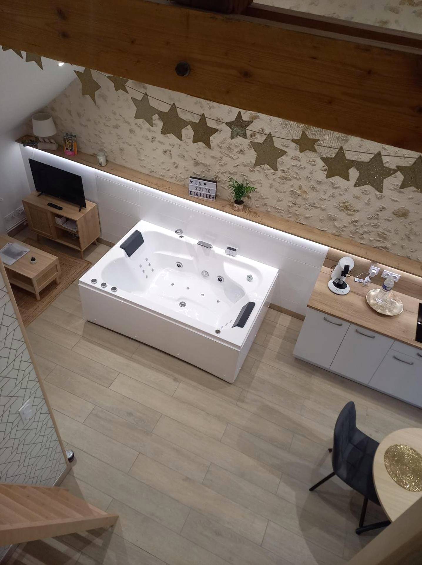 Baignoire balnéo blanche sous mur en pierre - Love Room Courgains - La Suite Etoilée - Balnéo privative