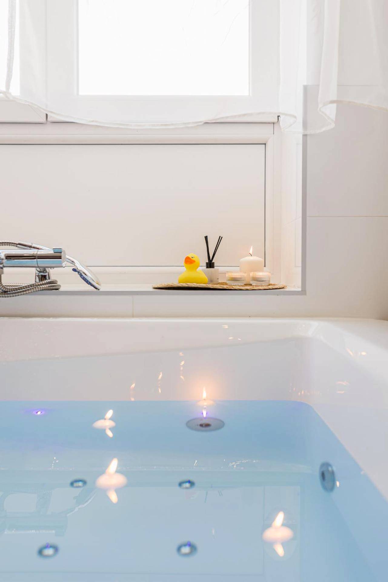 Détail de la baignoire avec bougies et canard - Suite Évasion Céleste à Saint - Étienne