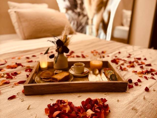 Cœur de pétales rouges et bougies sur le lit - LA SUITE DE L'EXTASE - LOVE ROOM - Jacuzzi privé & Terrasse - Parking et...
