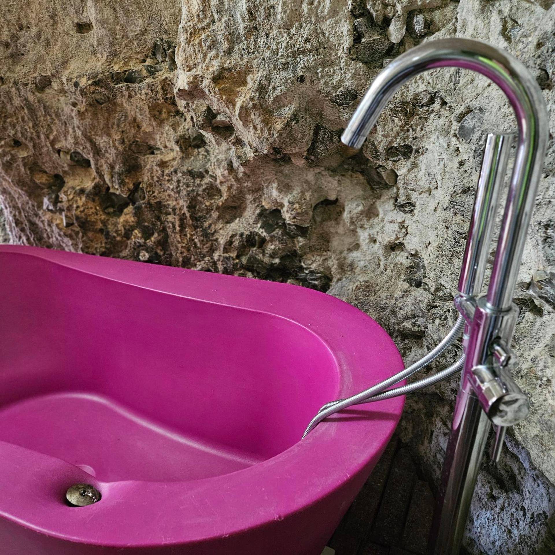 Baignoire îlot fuchsia contre paroi rocheuse - La suite des fouleries