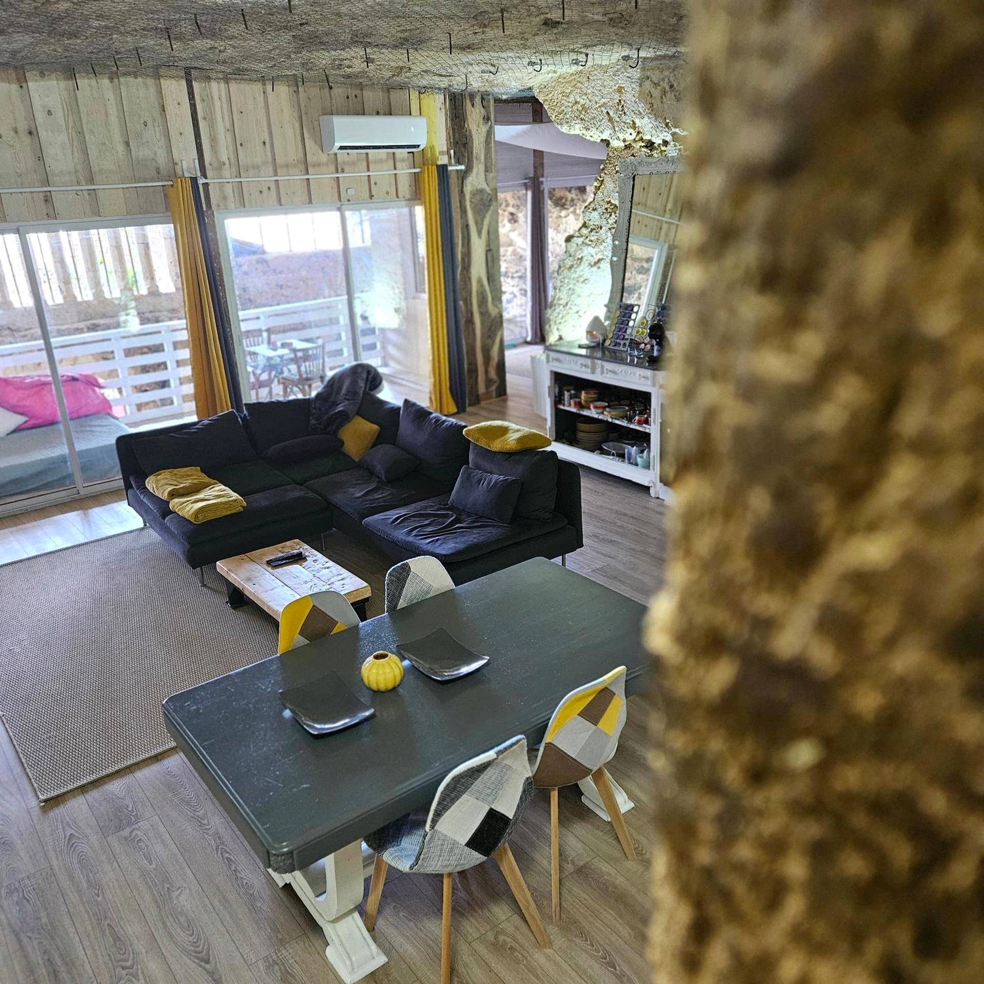 Salon avec canapé d'angle et coin repas - La suite des fouleries