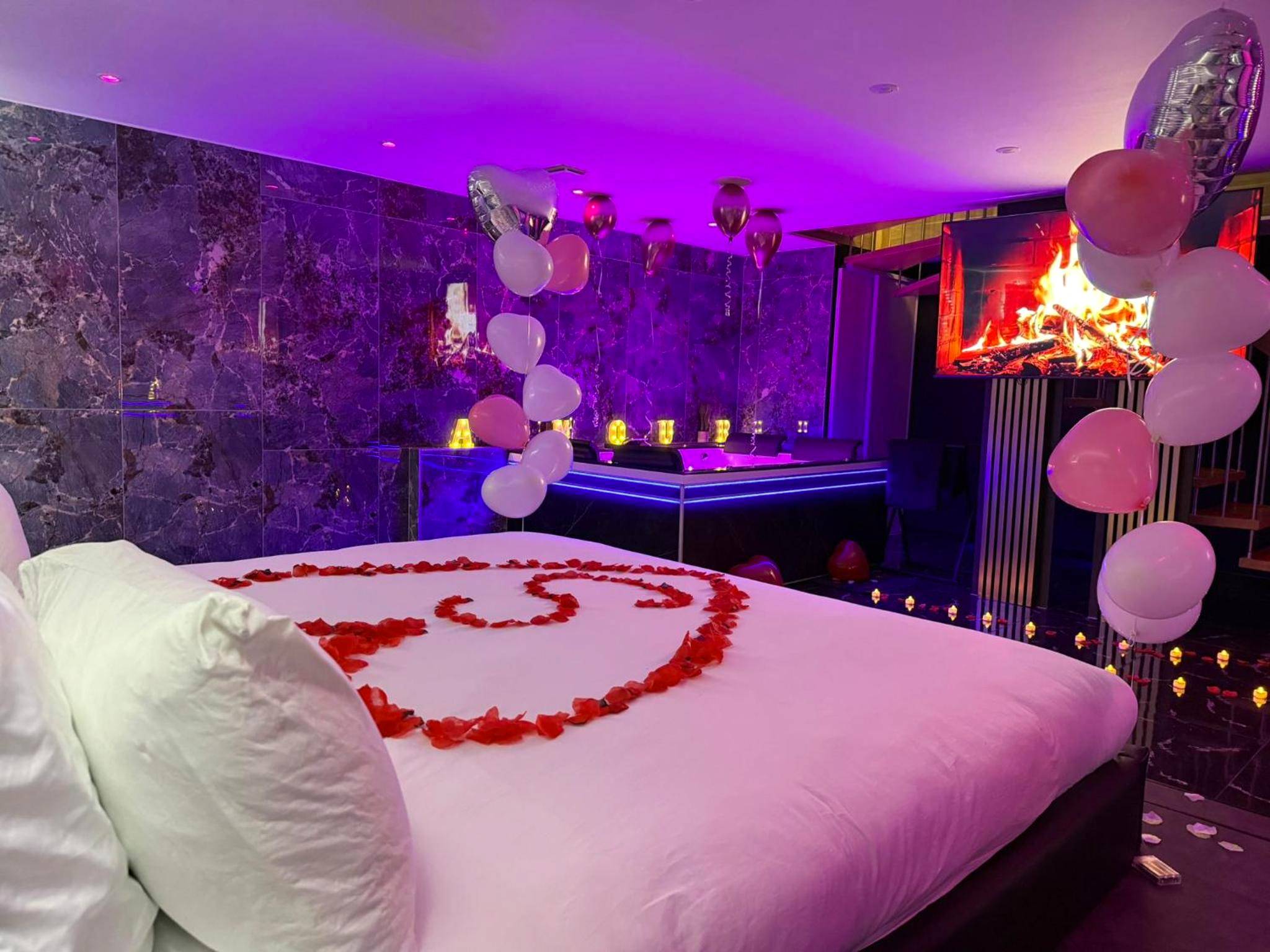 Lit avec pétales de rose en cœur et ballons - La Suite Genève Gaillard - Jacuzzi Privé & Séjour Luxe