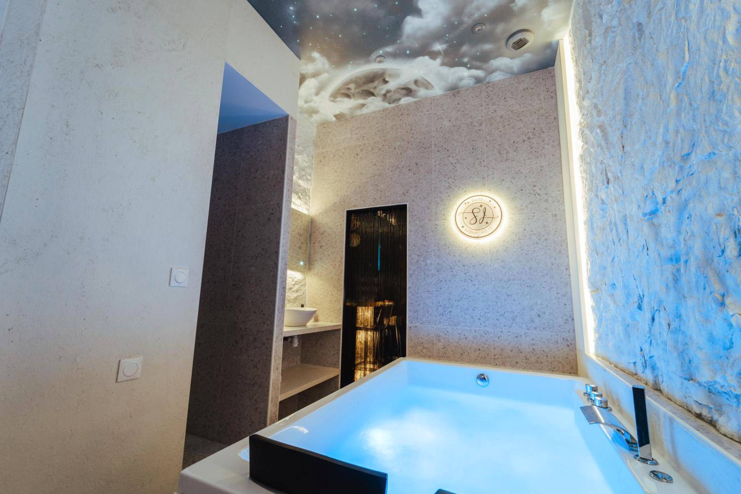Jacuzzi privatif avec éclairage bleu intégré - Suite Intemporelle