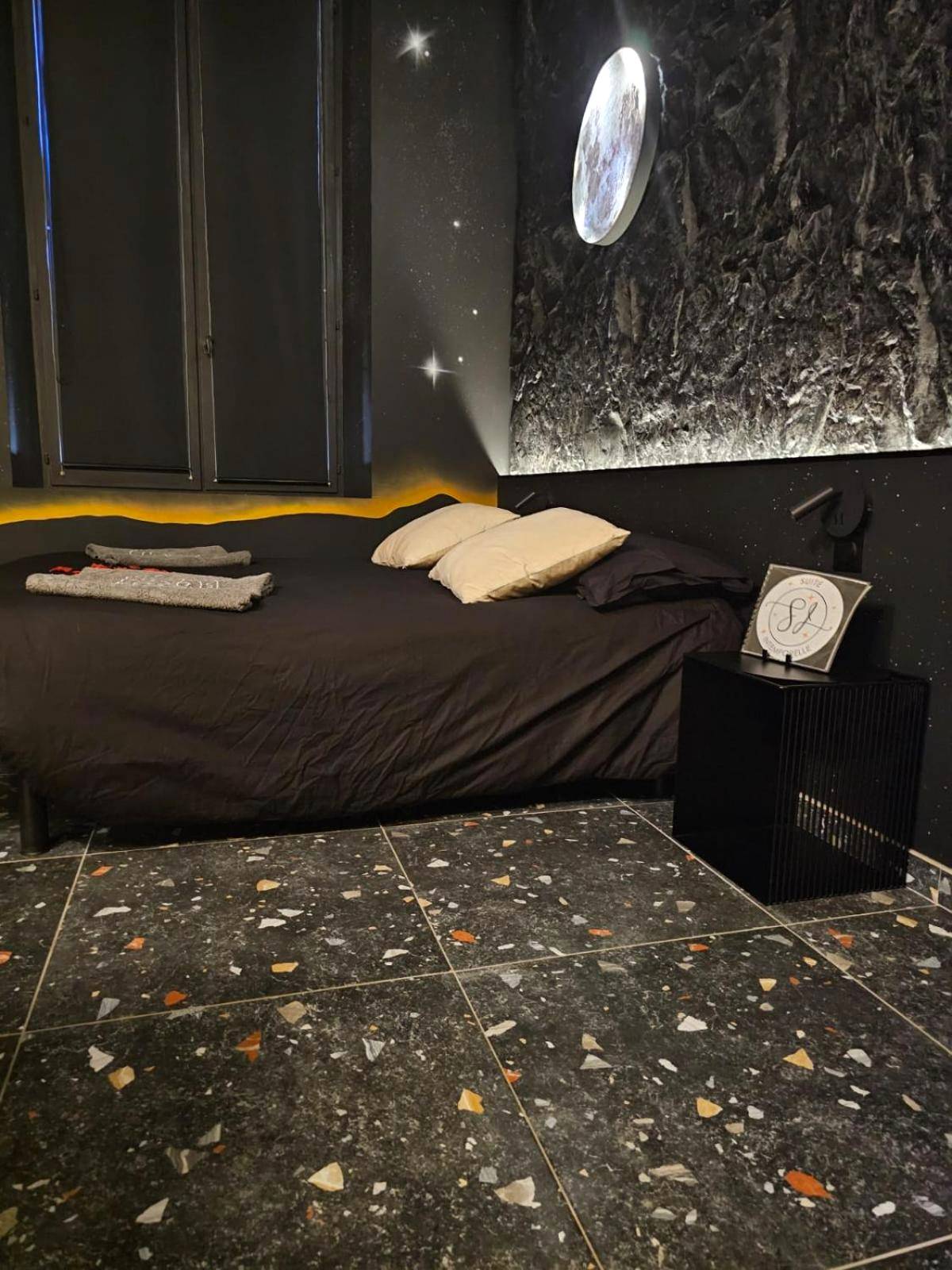 Lit double face à un mur de pierre éclairé - Suite Intemporelle