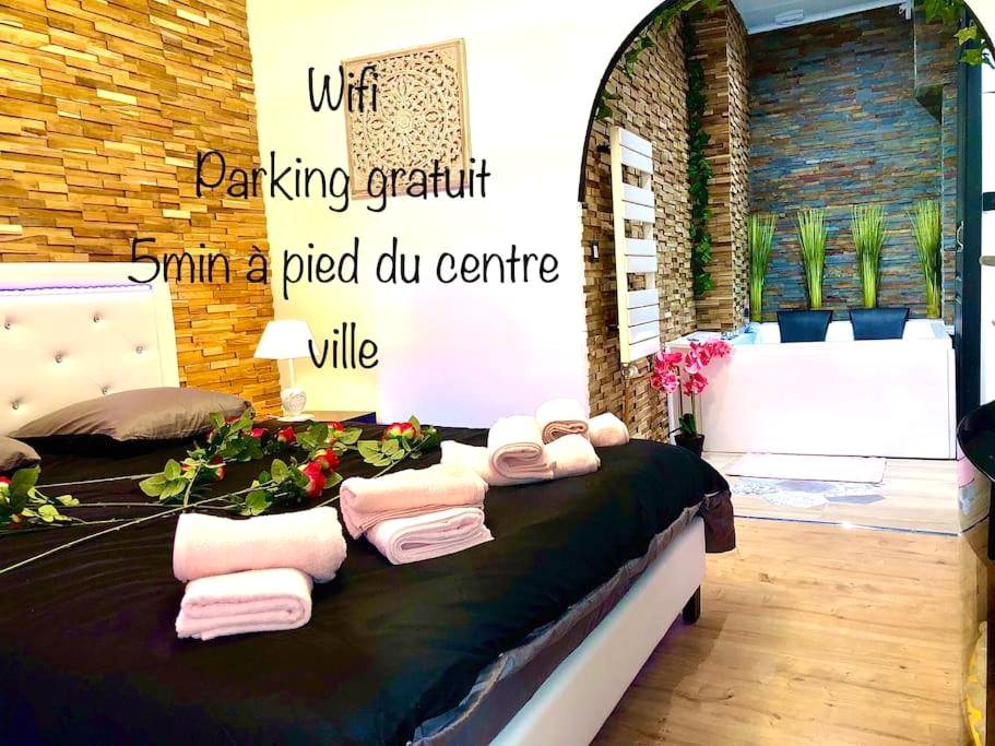 Lit king size avec roses et jacuzzi en fond - Love Room Sens - La suite romantique Jacuzzi,parking gratuit,centre