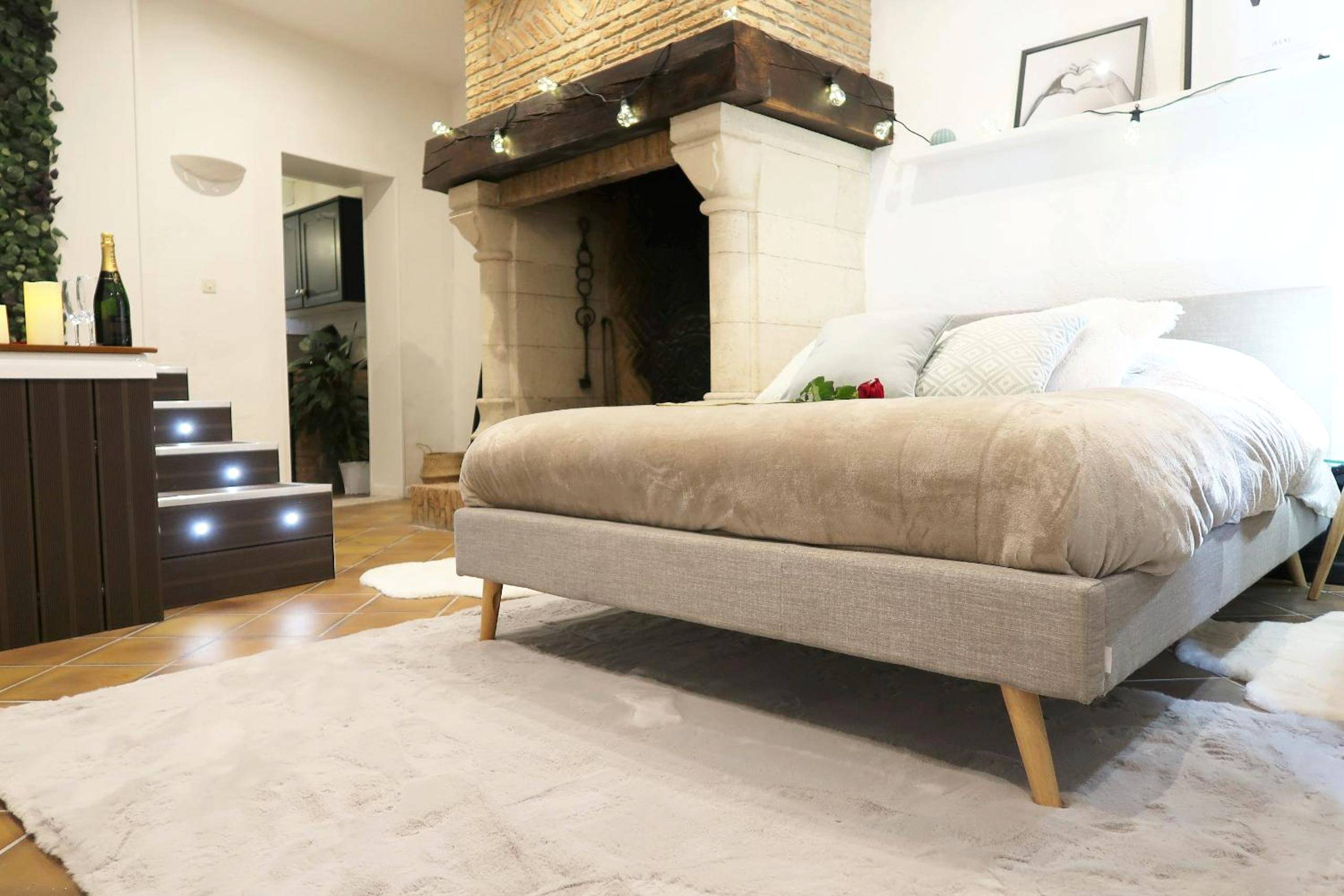 Lit double face à une grande cheminée en pierre - Intimiste parenthèse, Saint - La Suite, love room, Grand Jacuzzi, port...