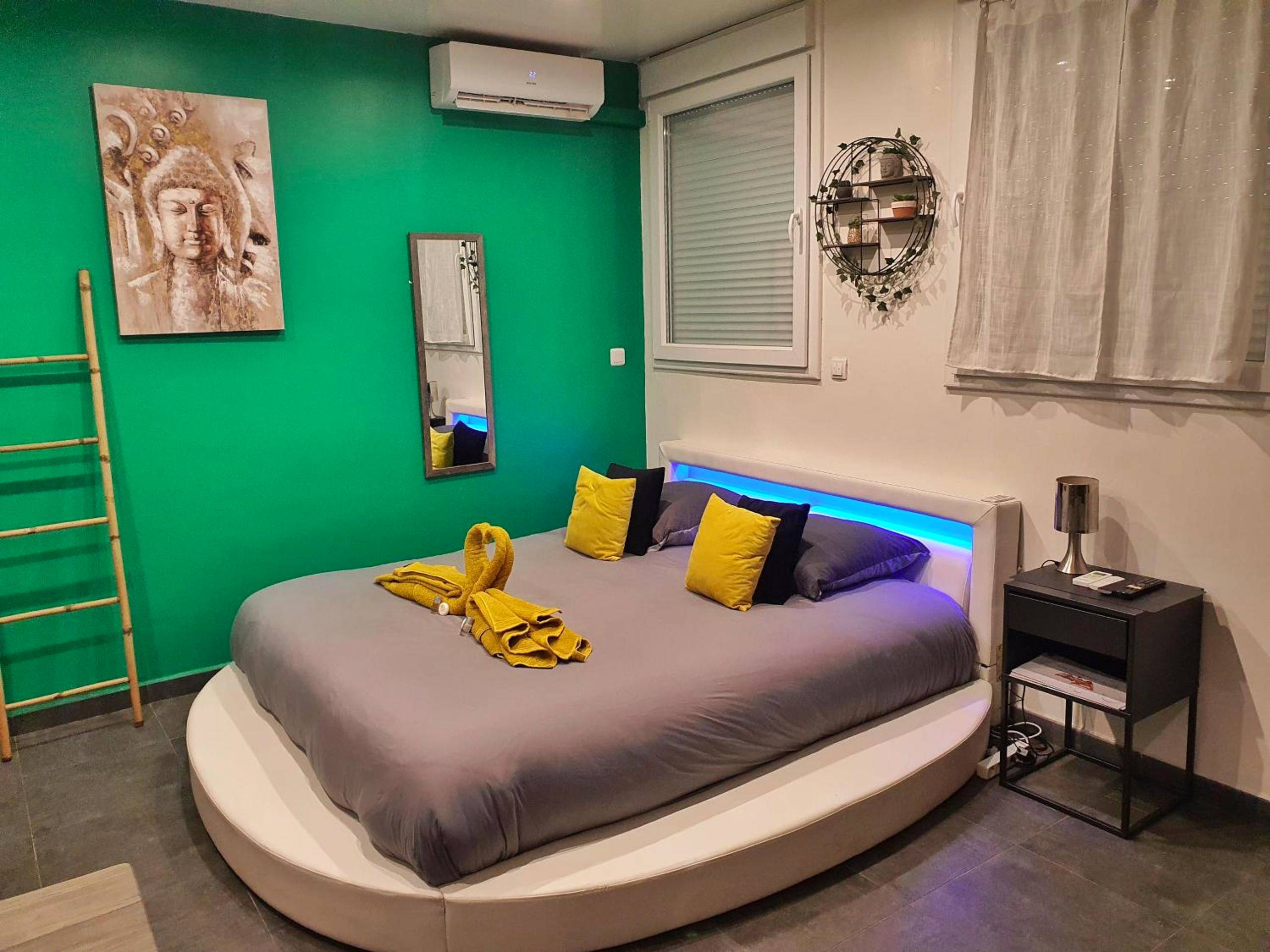 Lit rond avec éclairage LED bleu et déco Bouddha - Suite Jacuzzi Privatif Plage Des Catalans