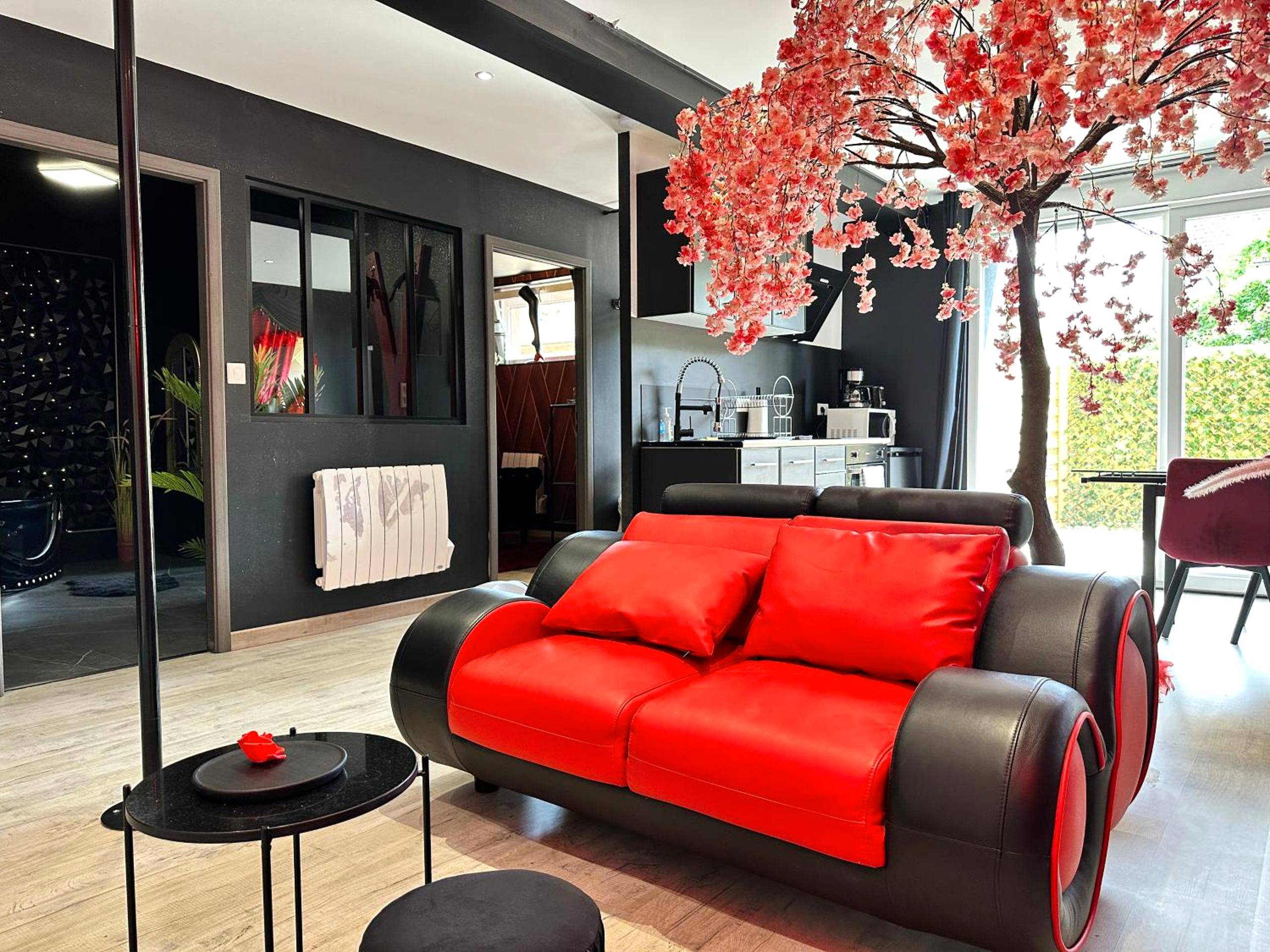 Canapé bicolore sous un cerisier artificiel - Love Room Saint - Dié - des - Vosges - Suite Jeux d’Amour Jacuzzi / Love Room