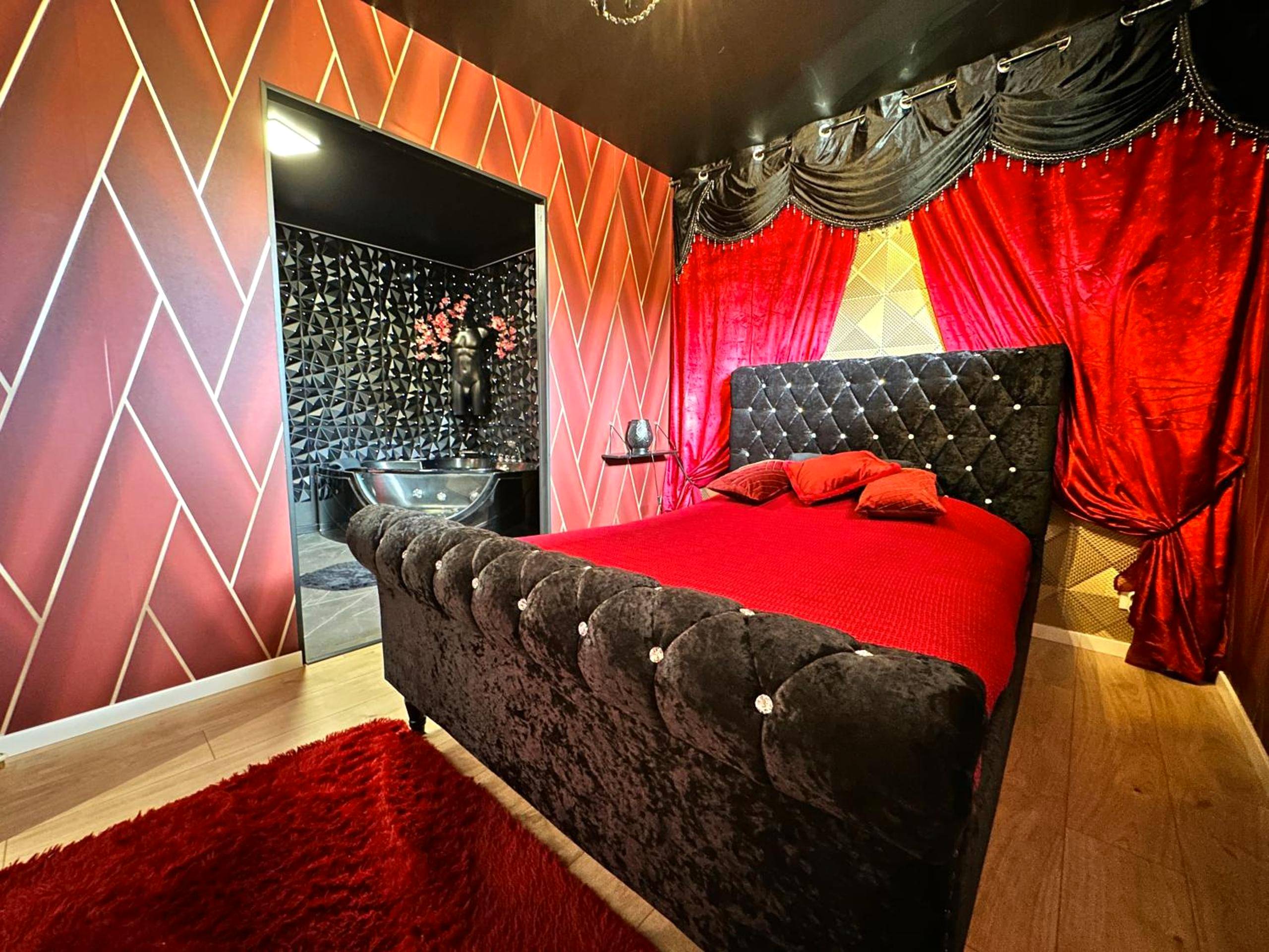 Lit capitonné avec rideaux de velours rouge - Suite Jeux d’Amour Jacuzzi / Love Room