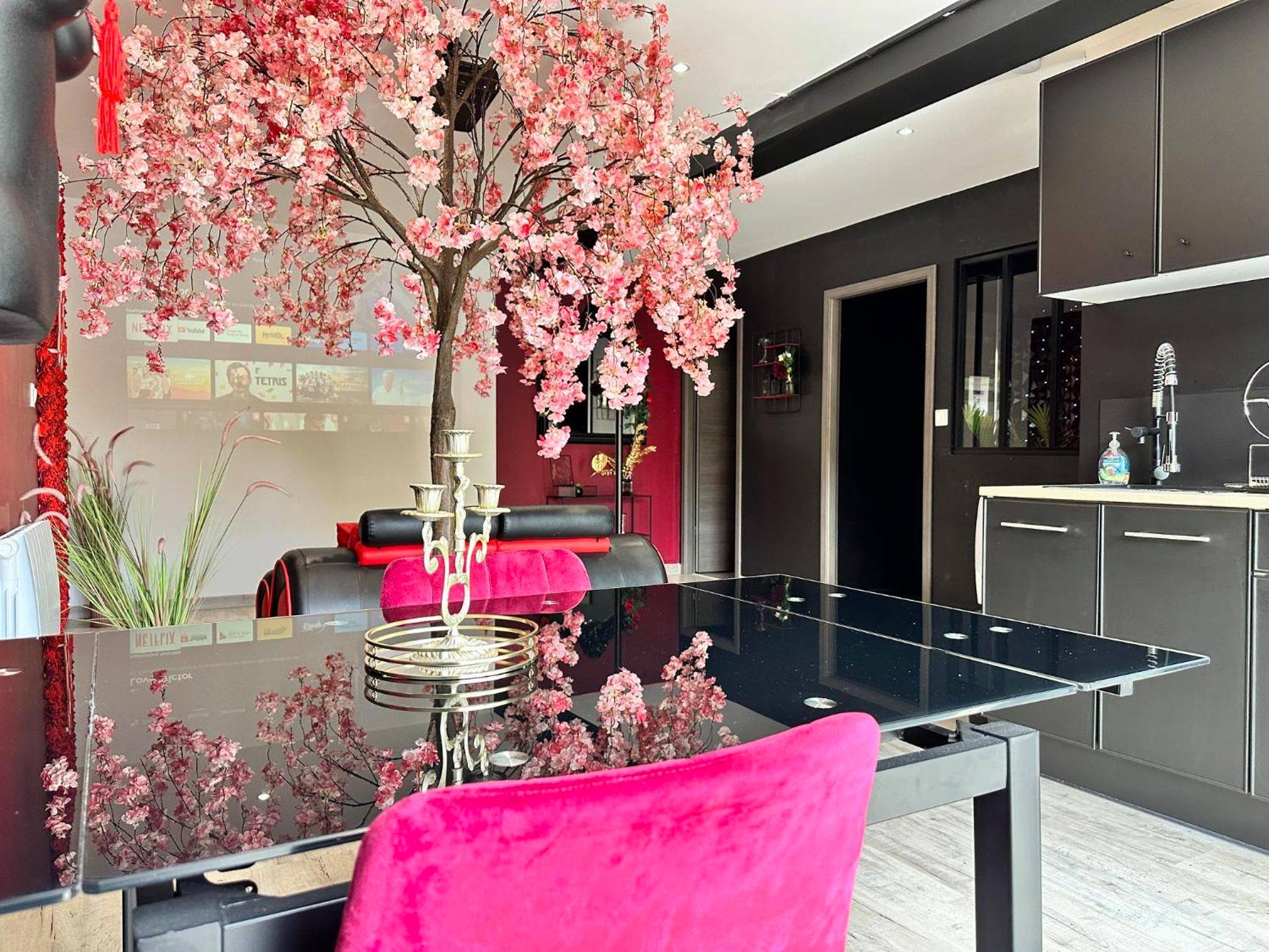 Table de repas noire et chaises en velours rose - Suite Jeux d’Amour Jacuzzi / Love Room