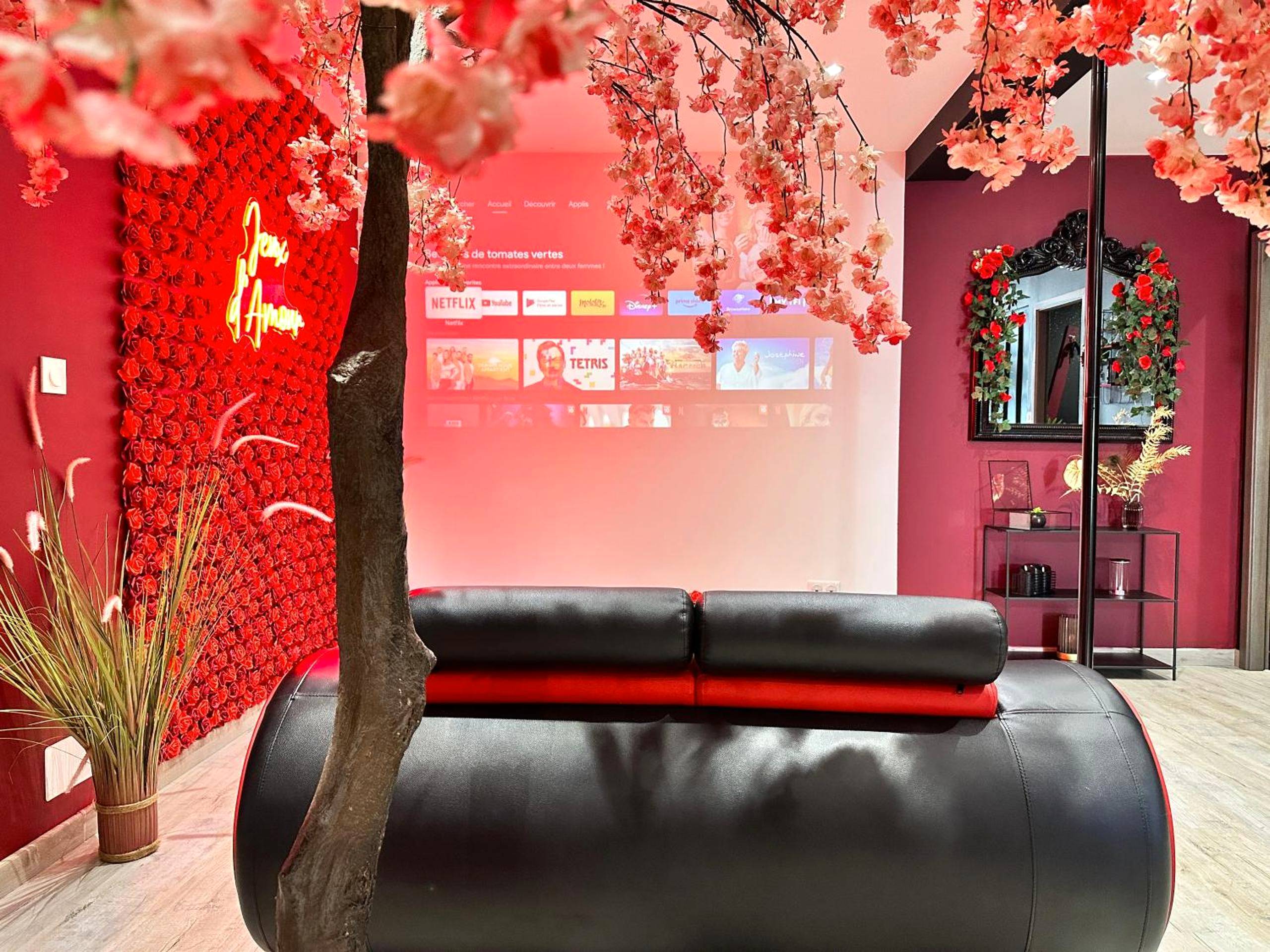 Écran de projection face au canapé design - Suite Jeux d’Amour Jacuzzi / Love Room
