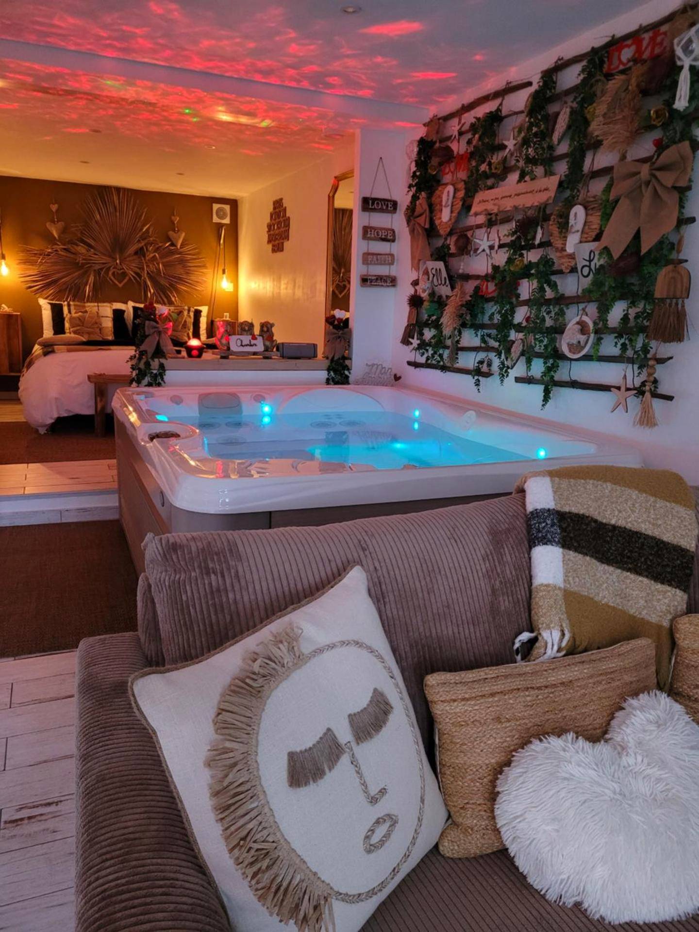 Espace salon avec canapé et jacuzzi éclairé - Suite & SPA Just Dream 28