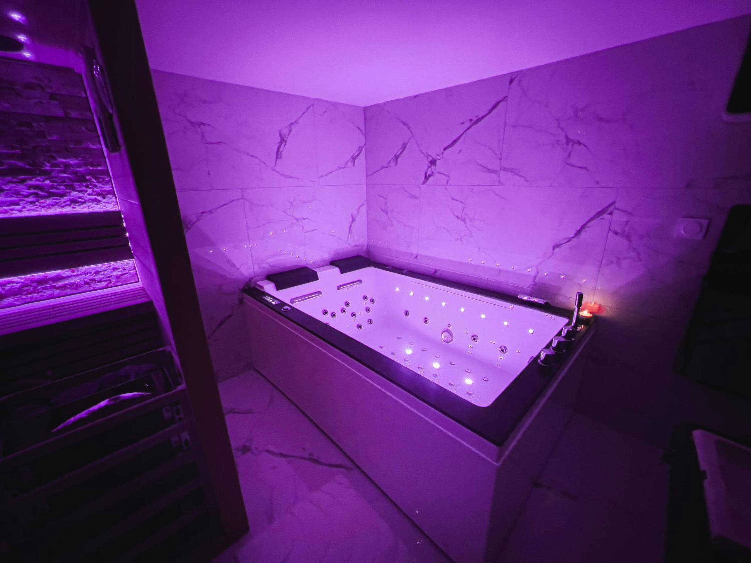 Baignoire balnéo avec éclairage LED violet - Love Room Lisieux - Cocon de Sainte - Suite KING Size SAUNA JACUZZI