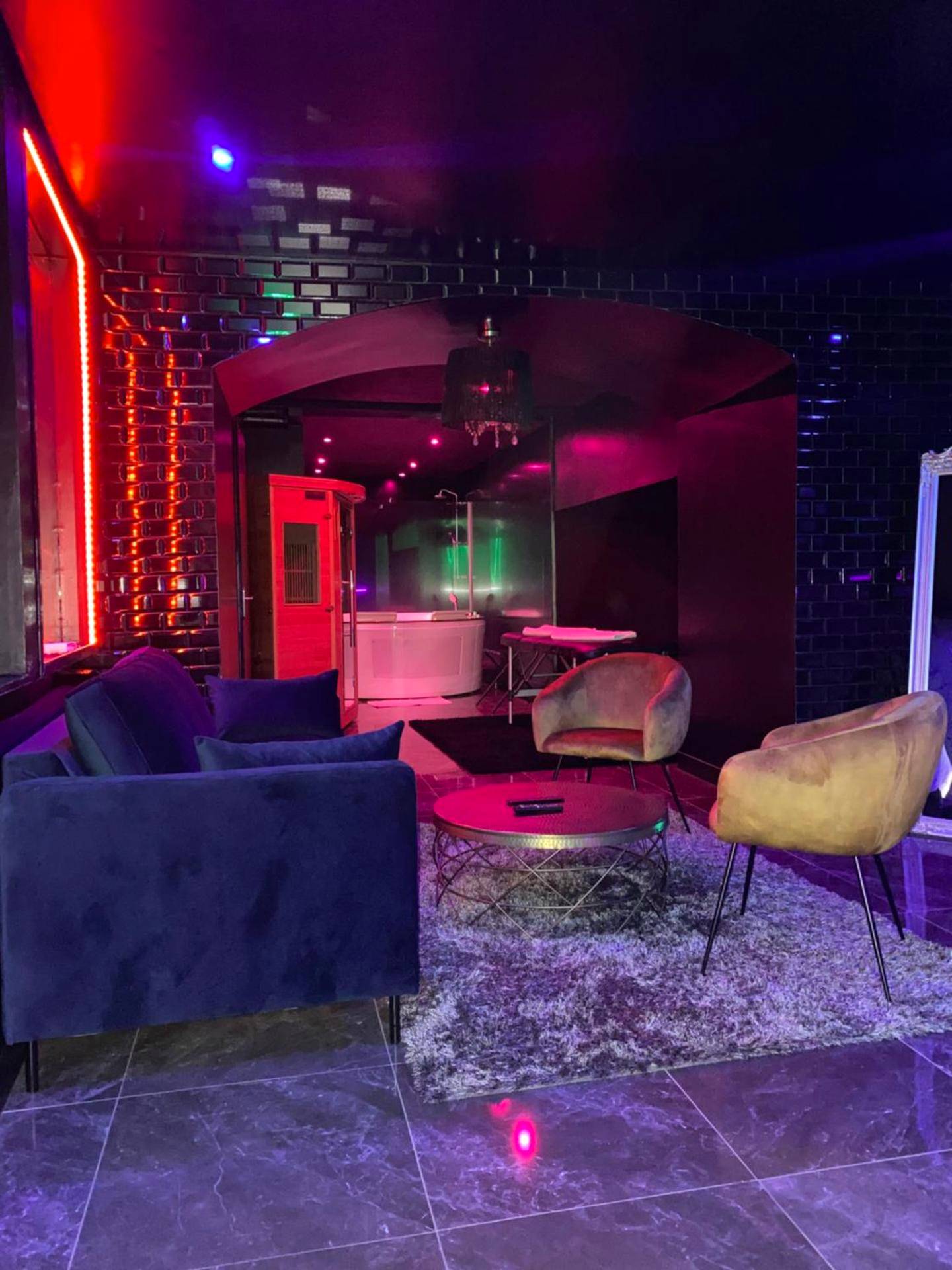 Salon avec canapé bleu et fauteuils en velours - Love Room Riom - La Suite Marylin, Loft de 90m2 avec Sauna et Jacuzzi