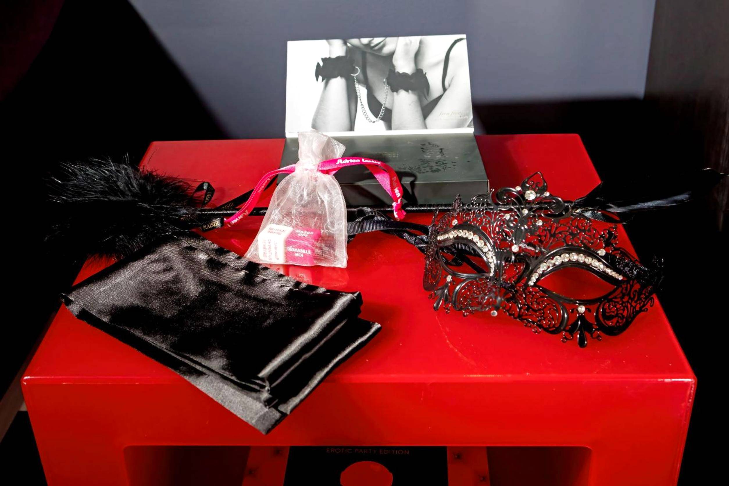 Accessoires de charme sur table de chevet rouge - SUITE PLAYROOM Love Hotel Toulouse