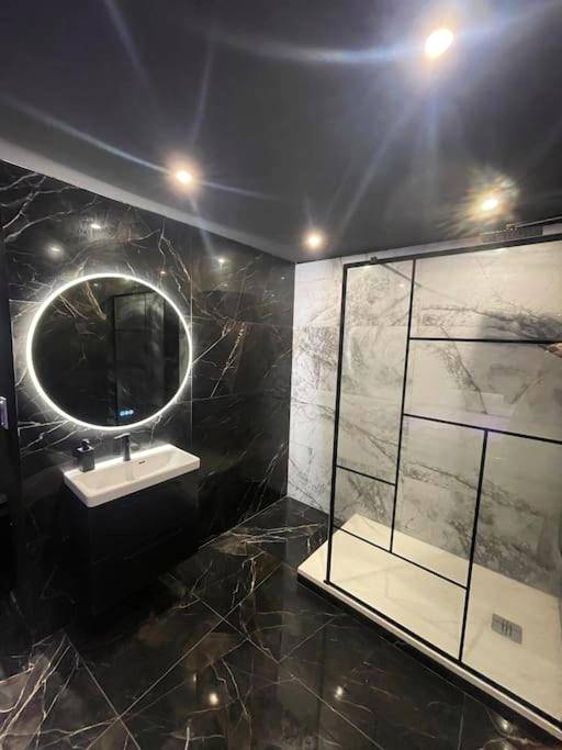 Salle de bain en marbre noir avec miroir LED - La Suite Prestige Jacuzzi,Sauna,Netflix,Disney