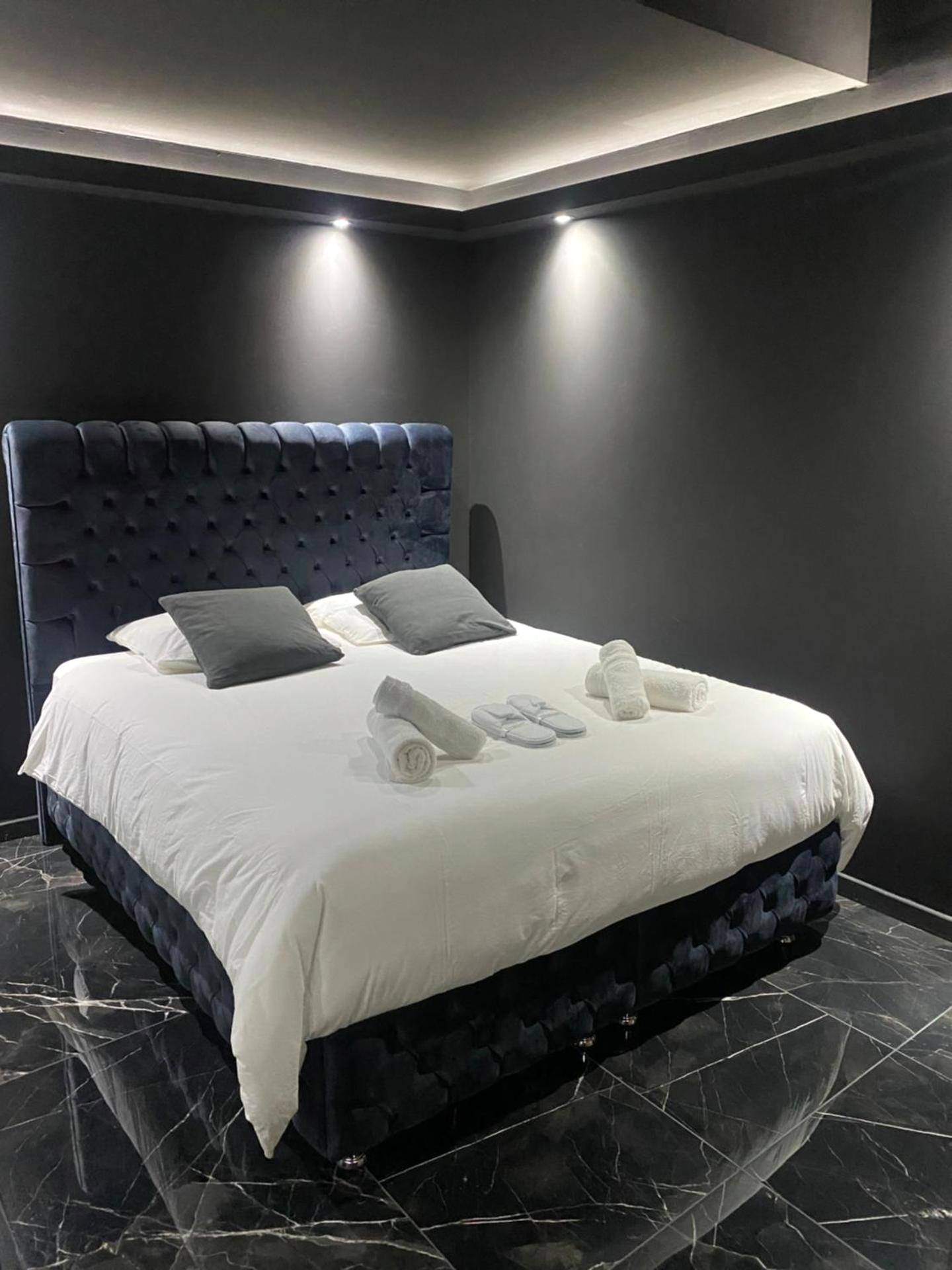 Lit double capitonné et sol en marbre noir - La Suite Prestige Jacuzzi,Sauna,Netflix,Disney