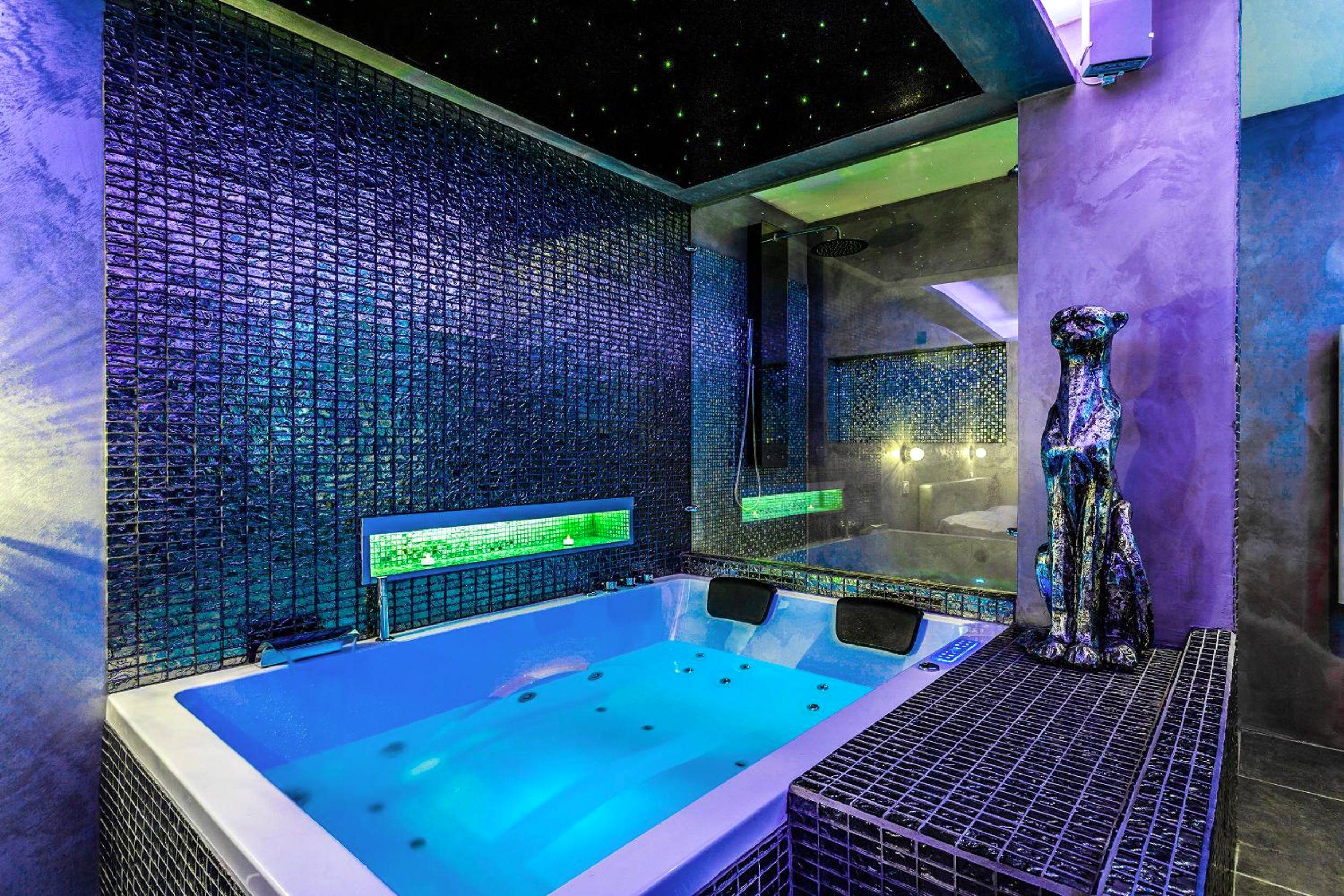 Baignoire balnéo éclairée en bleu et statue - Suite Romantique