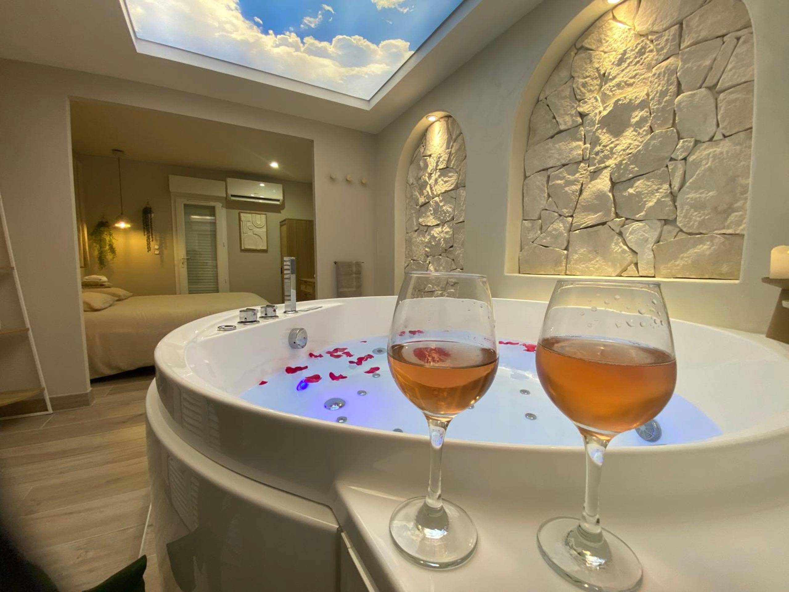 Jacuzzi avec pétales de rose et verres de vin - Love Room Valras - Plage - Suite Saint Pierre