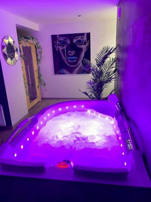 Jacuzzi privatif avec éclairage LED violet - Love Room Nancy - La Suite Saphir – spa privatif