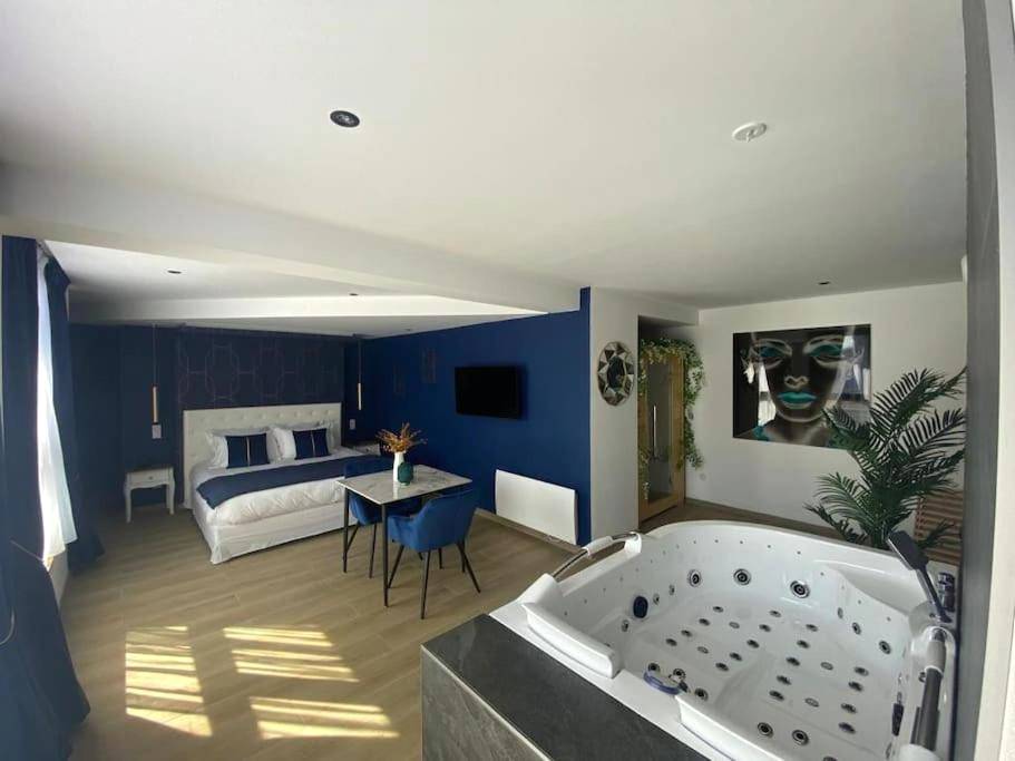 Suite avec lit king size, coin repas et spa - La Suite Saphir – spa privatif