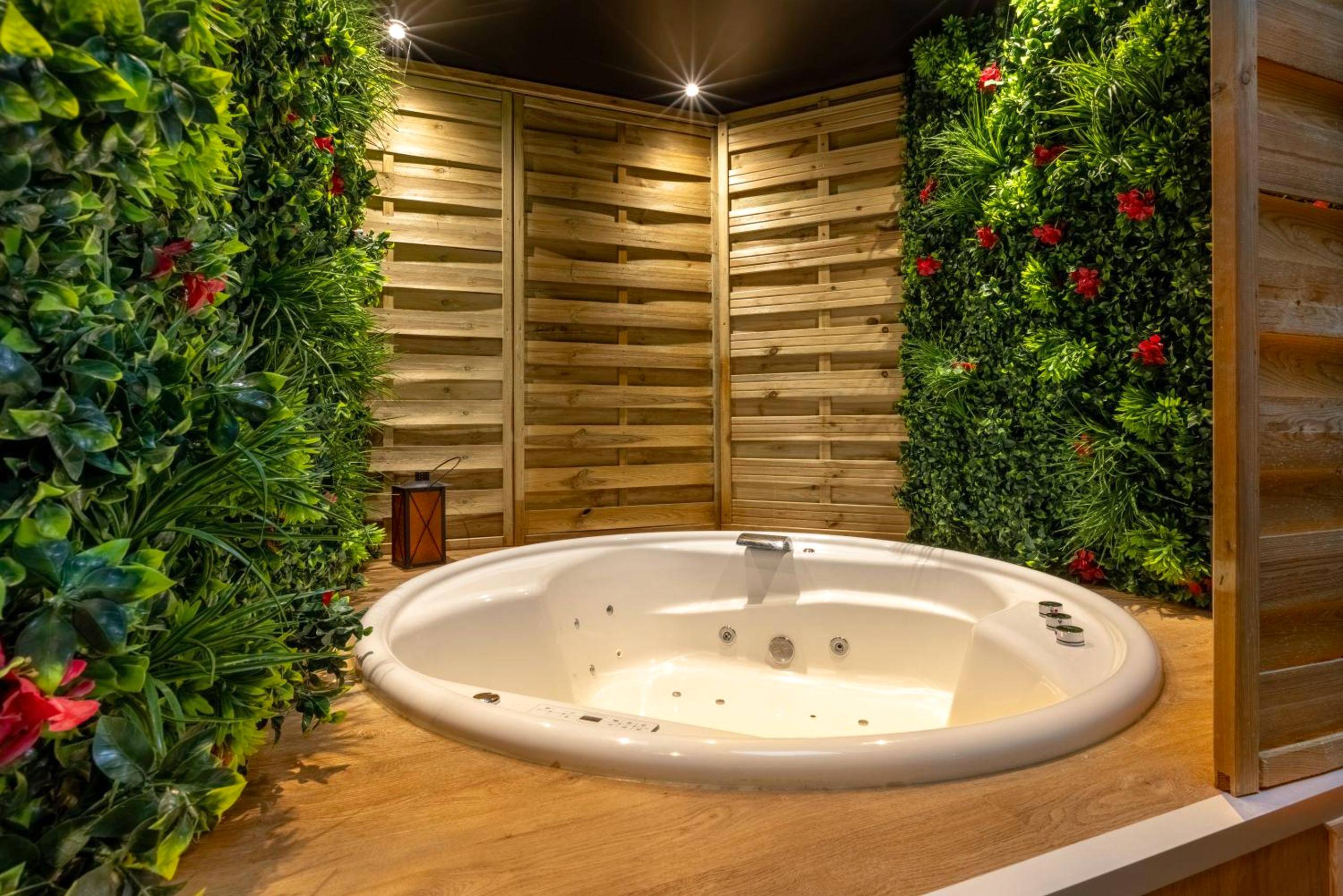 Jacuzzi rond entouré de murs végétaux et bois - Love Room Boulogne - sur - Mer - LA SUITE SEPT LE BRAS DOR
