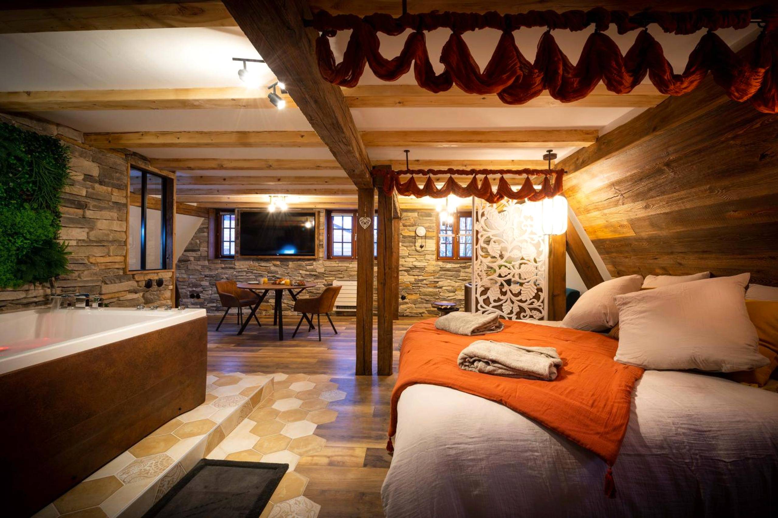 Chambre ouverte avec lit double et coin repas - Suite & SPA 1566 Benfeld